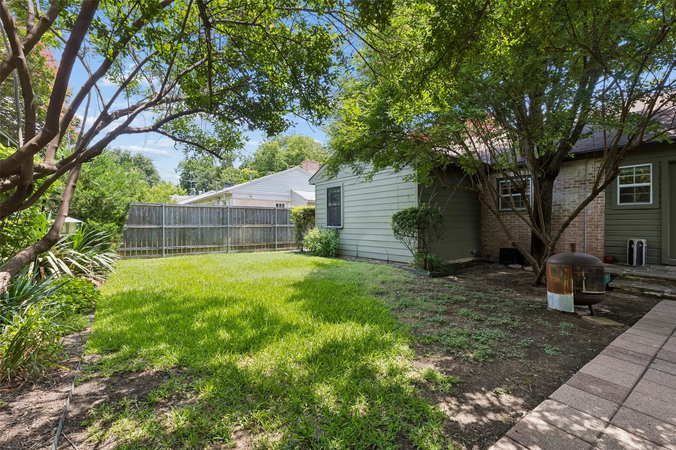 Expansive grassy area with mature trees providing coverage