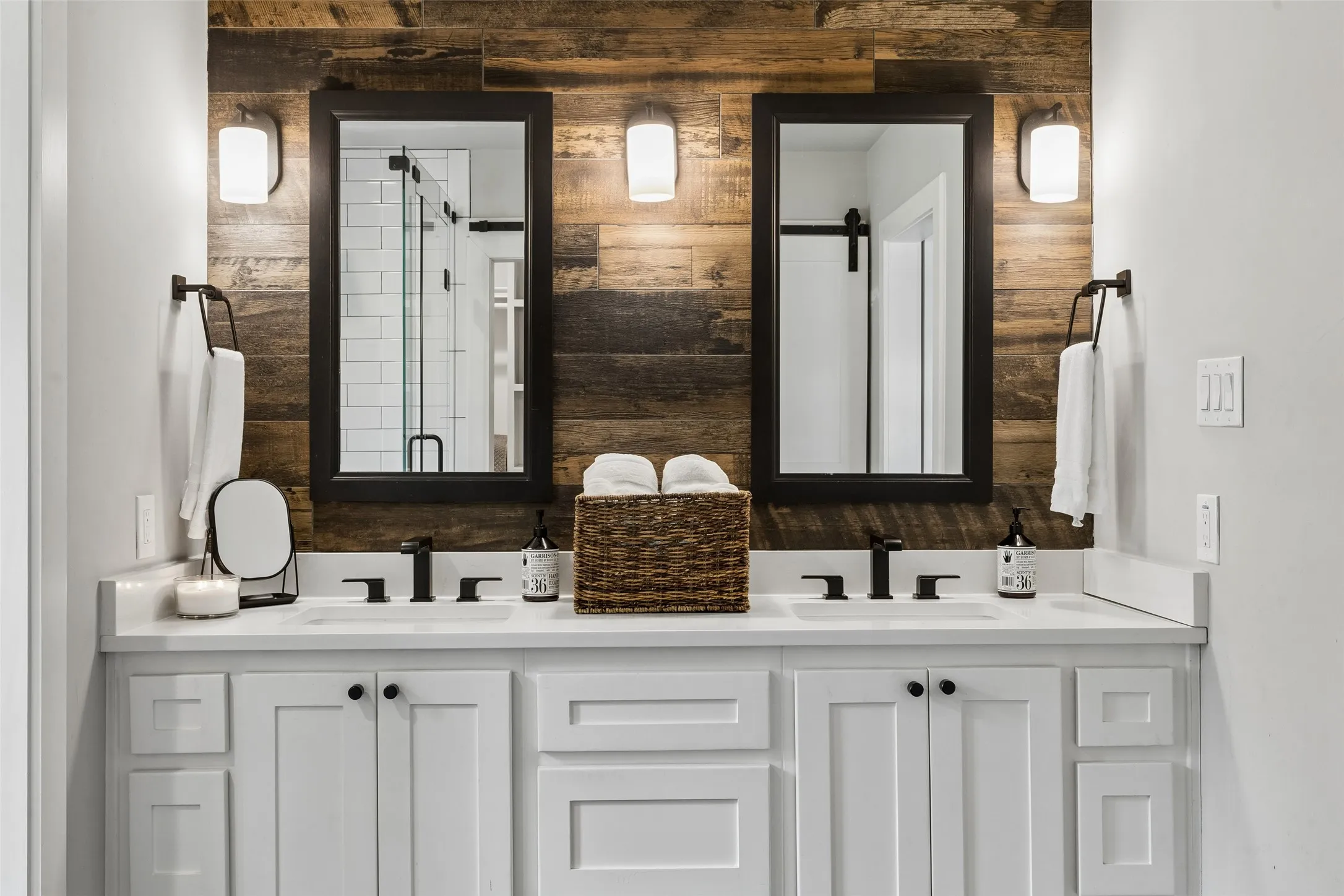 Dual vanity with white cabinetry, white countertops, and matte black fixtures