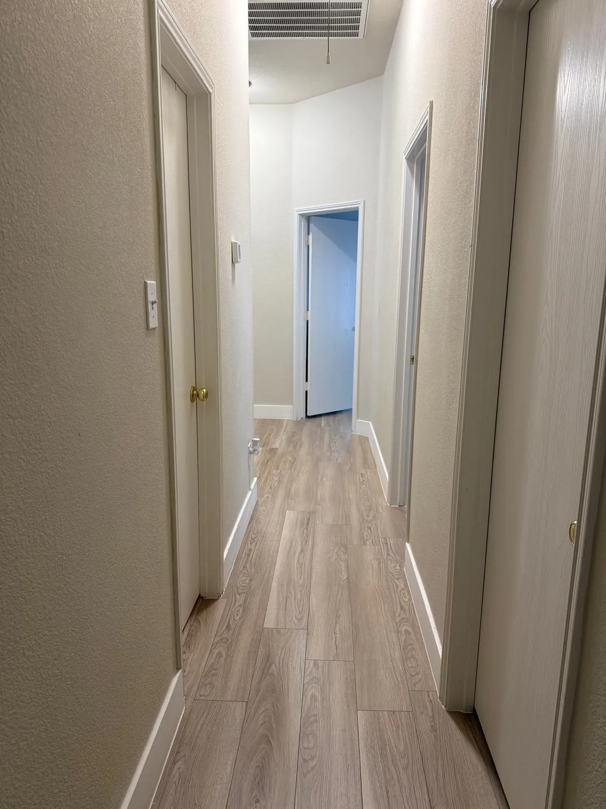 Wood-finish flooring throughout, complemented by light-colored walls and white trim