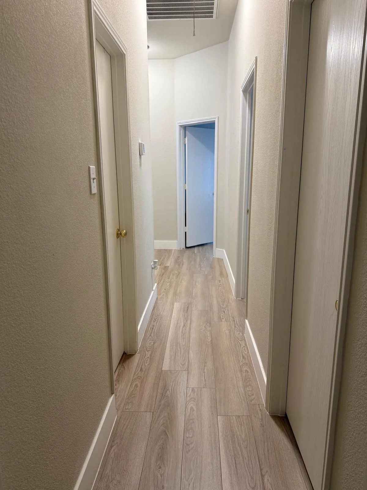 Wood-finish flooring throughout the hallway