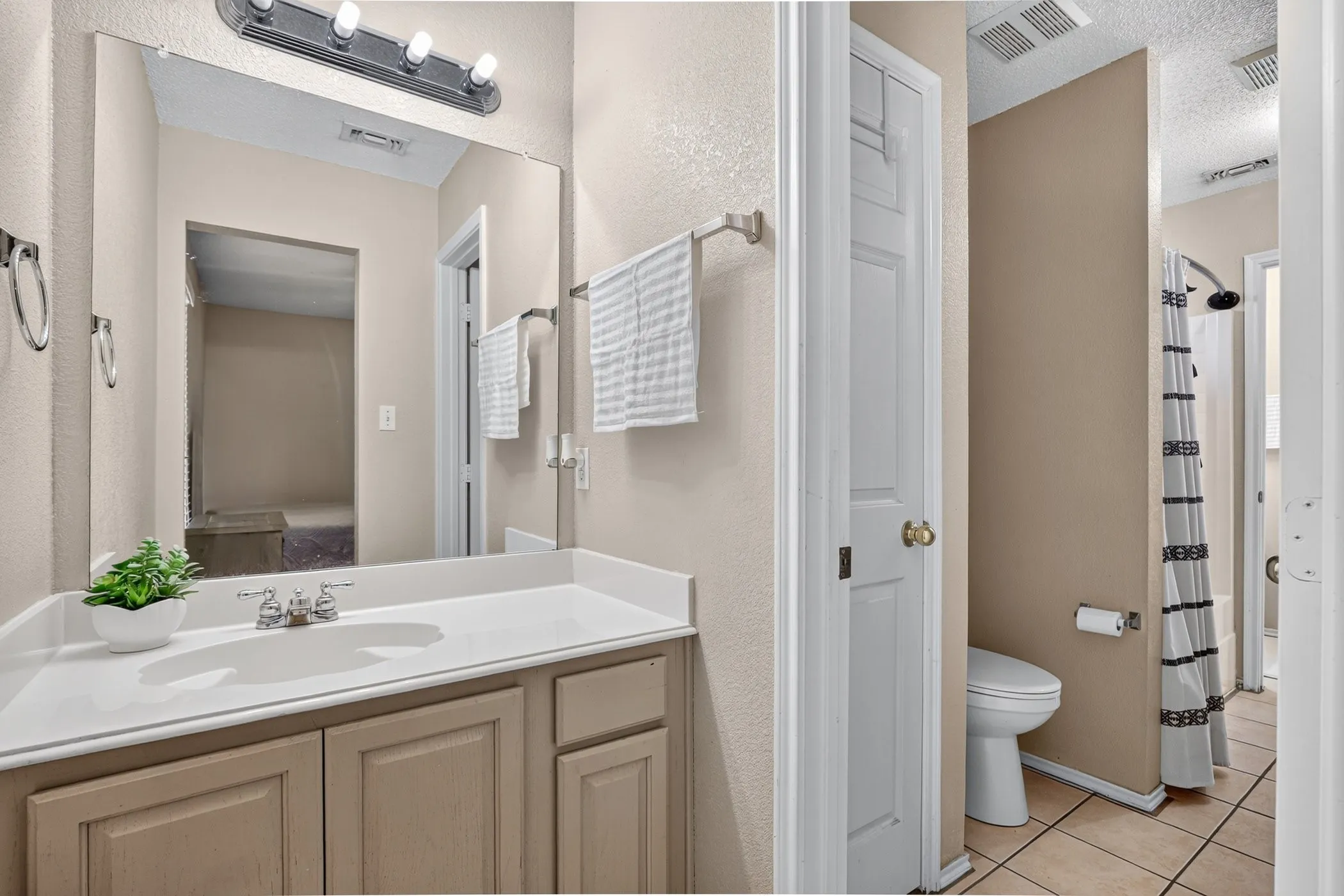 Vanity with an integrated sink, polished chrome faucet, and under-sink cabinetry