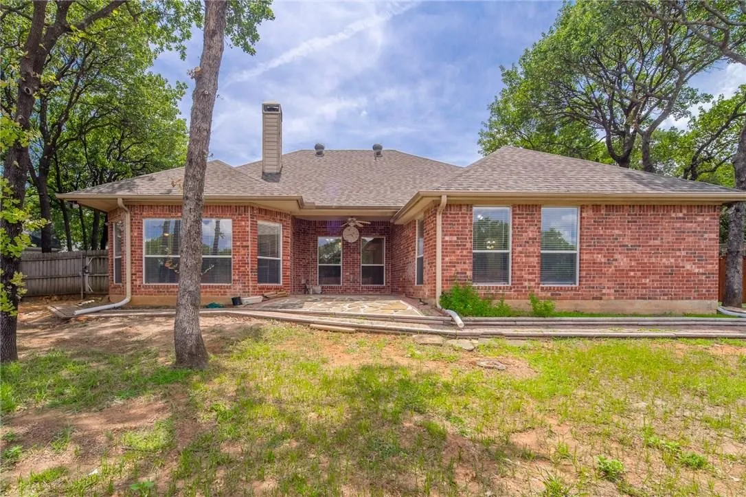 Brick exterior with multiple windows and a covered patio