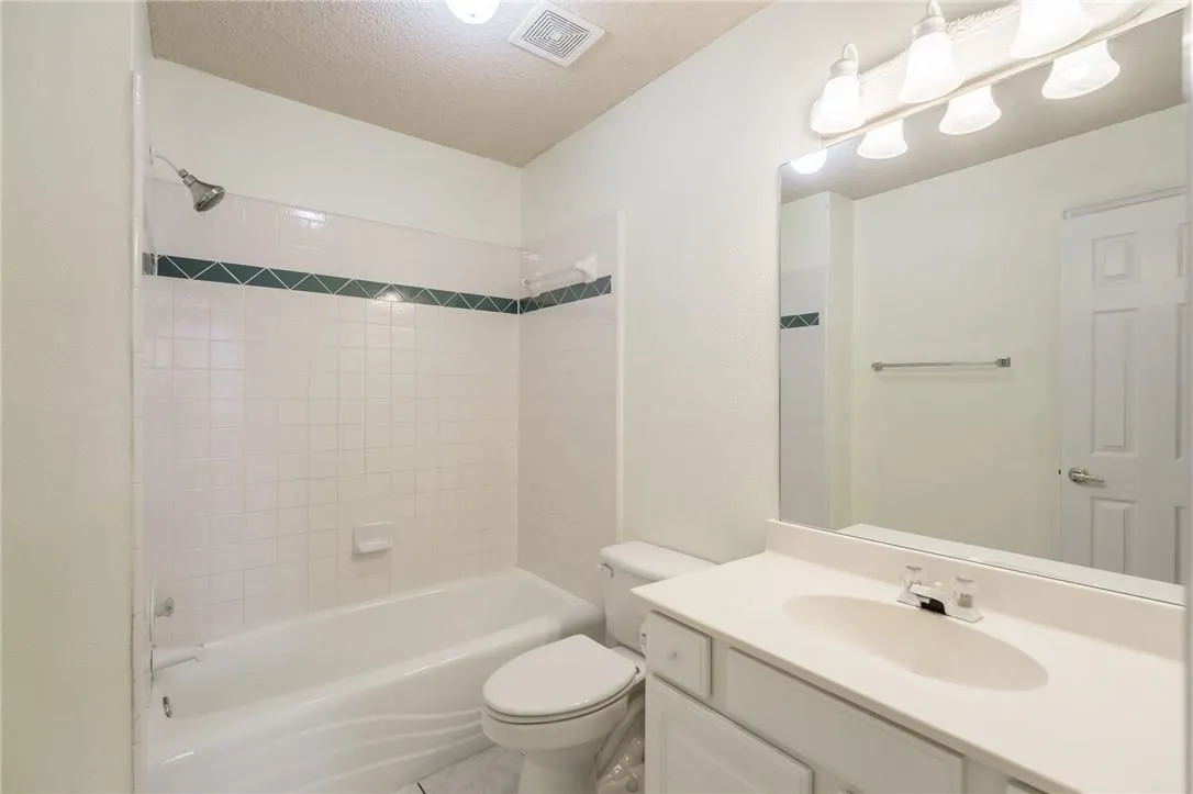 White tiled shower surround with decorative accent band