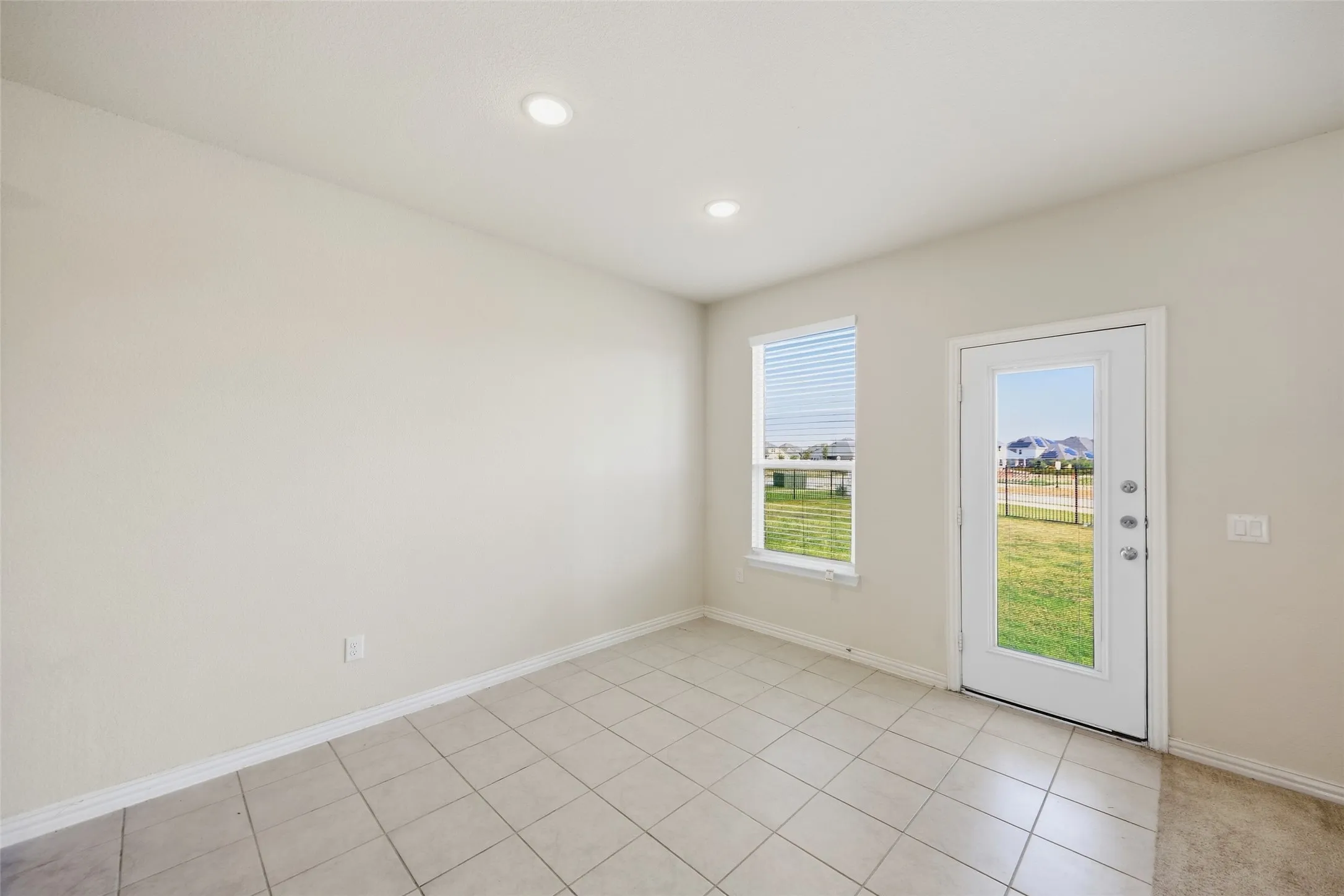 Recessed ceiling lighting, tiled flooring, single window with blinds, full-lite exterior door, light-toned wall finish