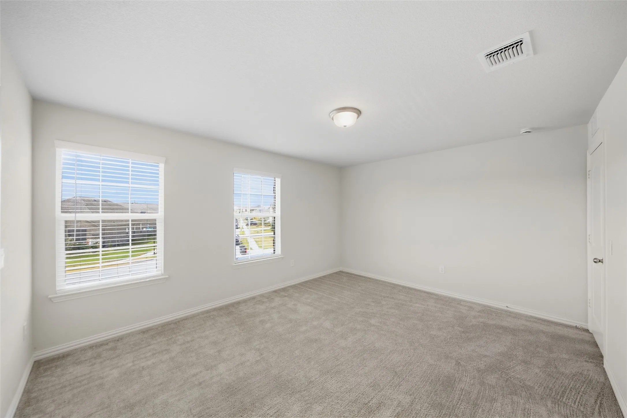 Neutral wall finishes, recessed lighting, and carpeted flooring