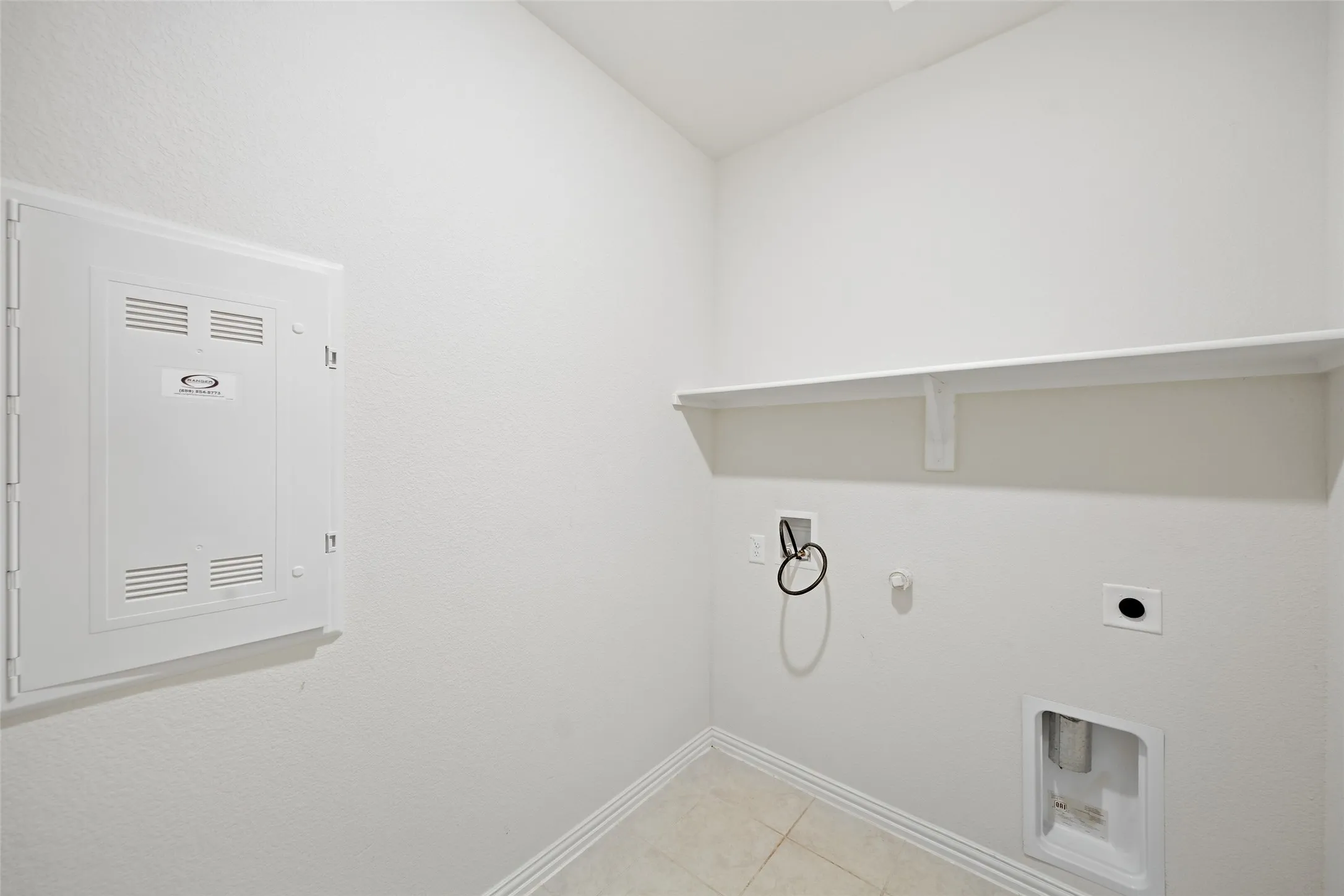 Built-in shelving, tile flooring, and utility hookups