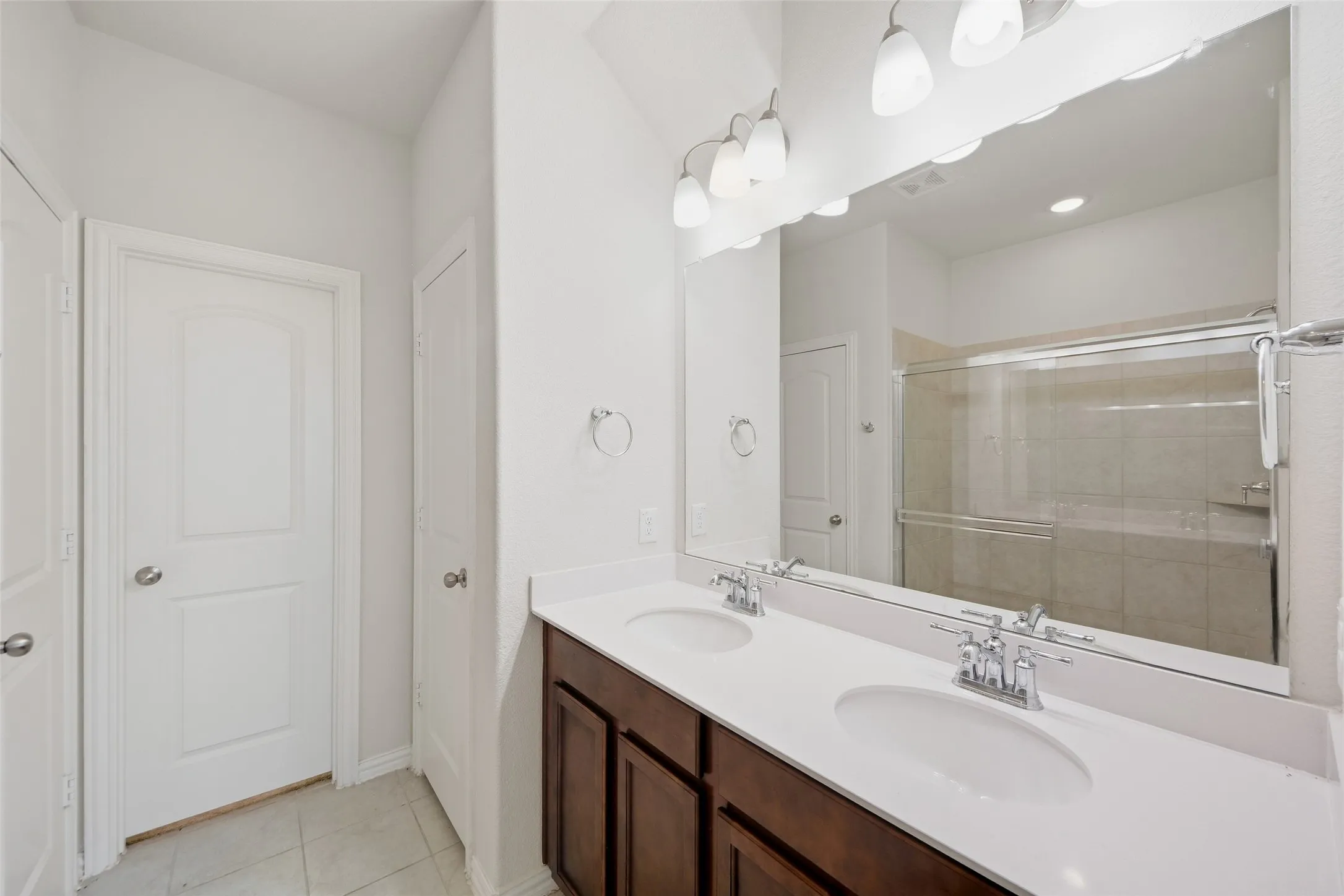 Dual vanity with white countertops, undermount sinks, and chrome faucets