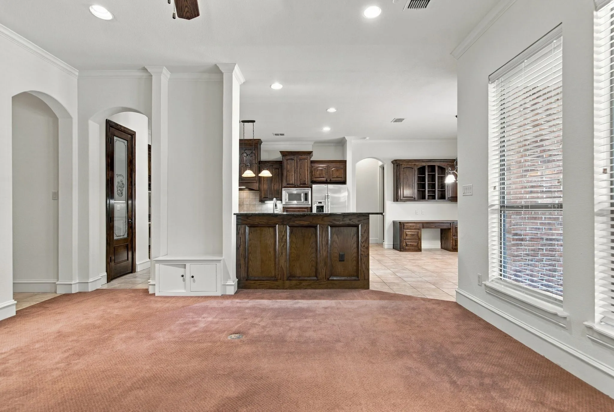 Arched doorways, recessed lighting, and a built-in cabinet