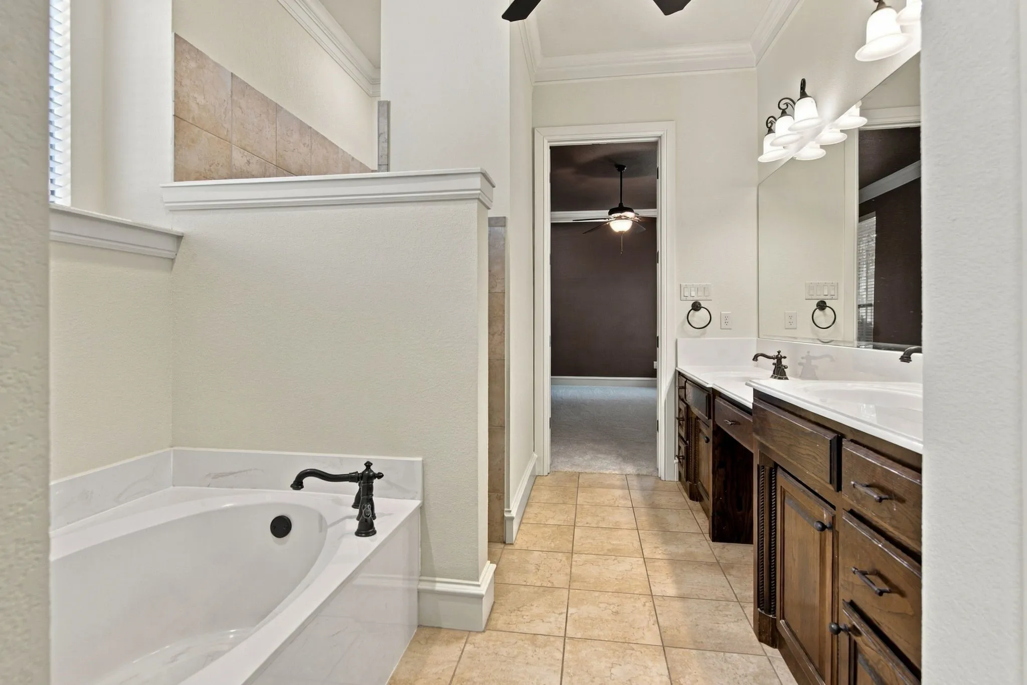 Dual vanity with dark wood-finish cabinetry, integrated sinks, and bronze-finish fixtures