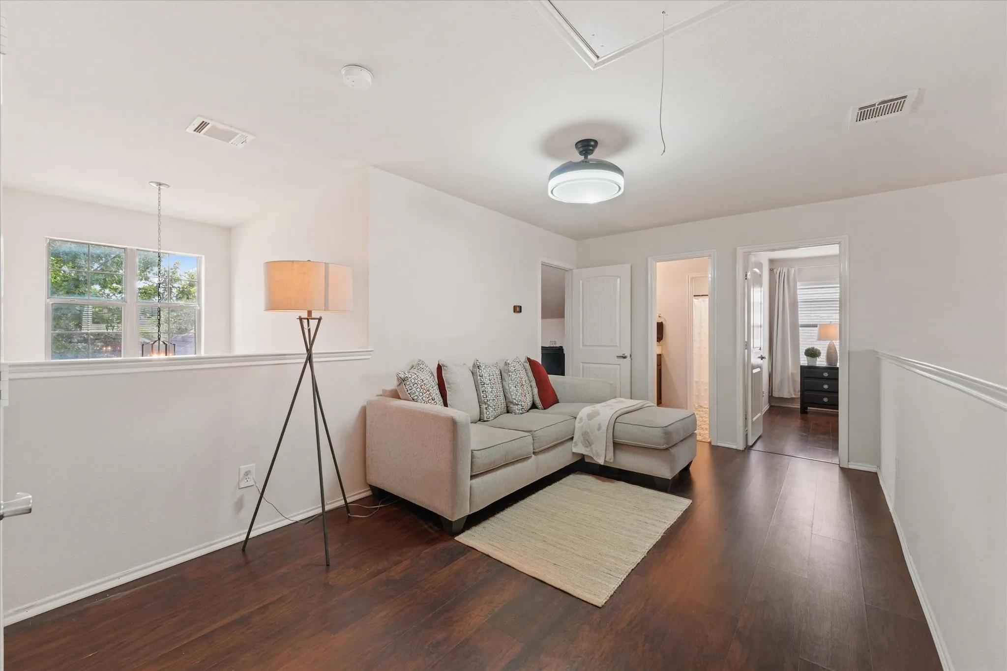 Dark wood-finish flooring, white painted walls, and a modern ceiling fixture