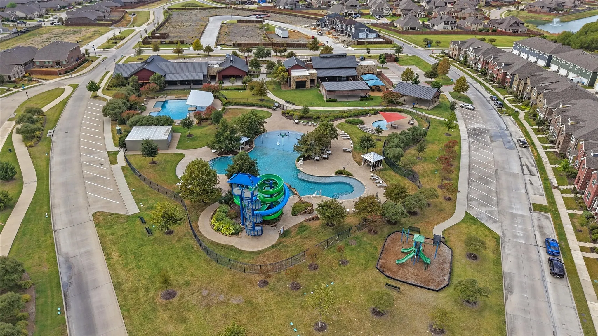 Community amenities featuring multiple swimming pools, water slides, a splash pad, and a playground