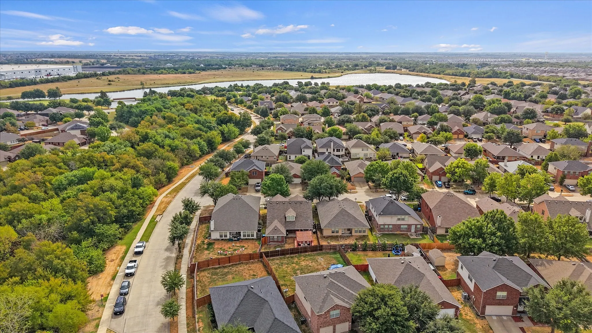 Residential neighborhood with a variety of single-family homes, mature trees, and a distant body of water
