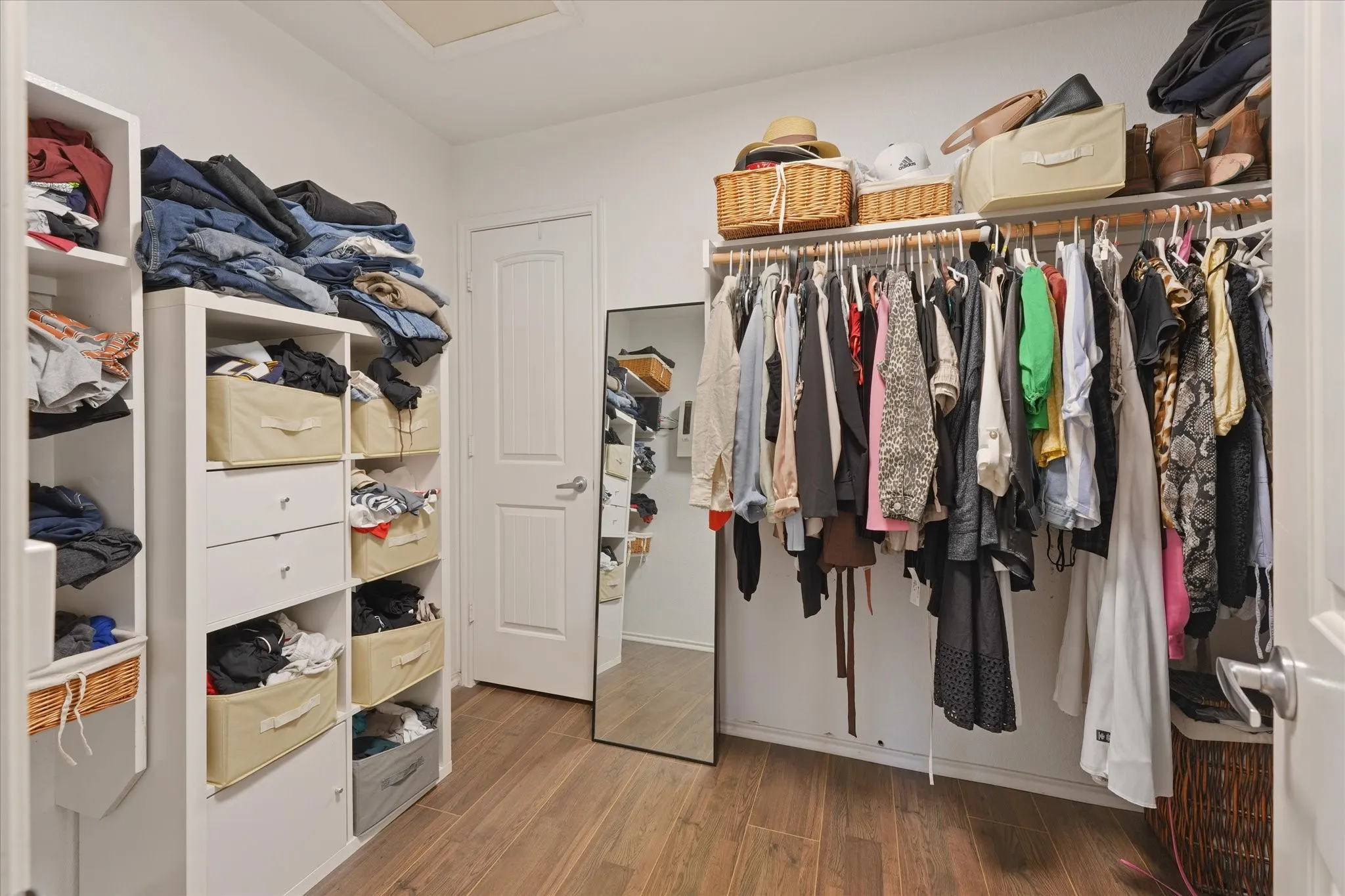 Wood-finish flooring with white walls and built-in shelving