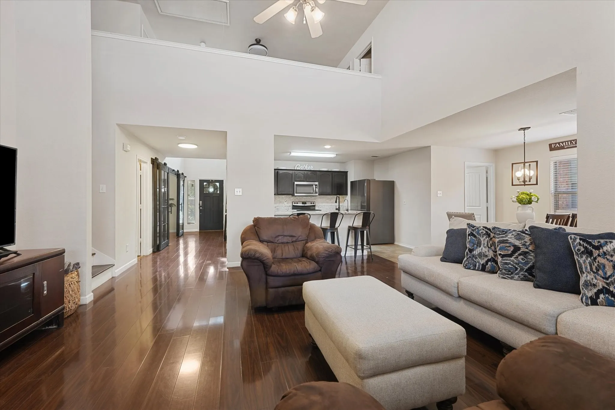 Spacious living area featuring high ceilings, wood-finish flooring, and an open-concept layout