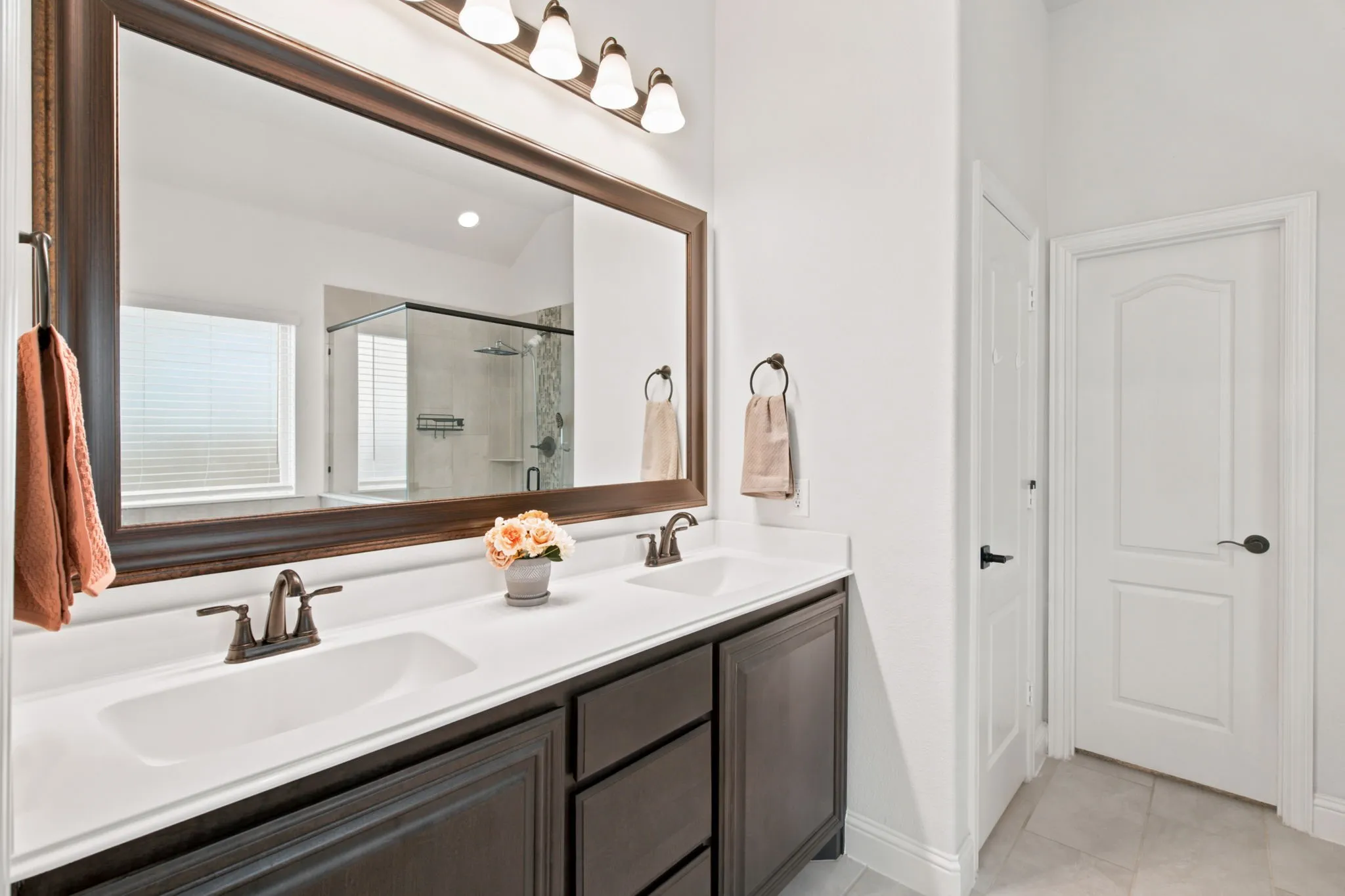 Dual vanity with dark wood-finish cabinetry and white countertops