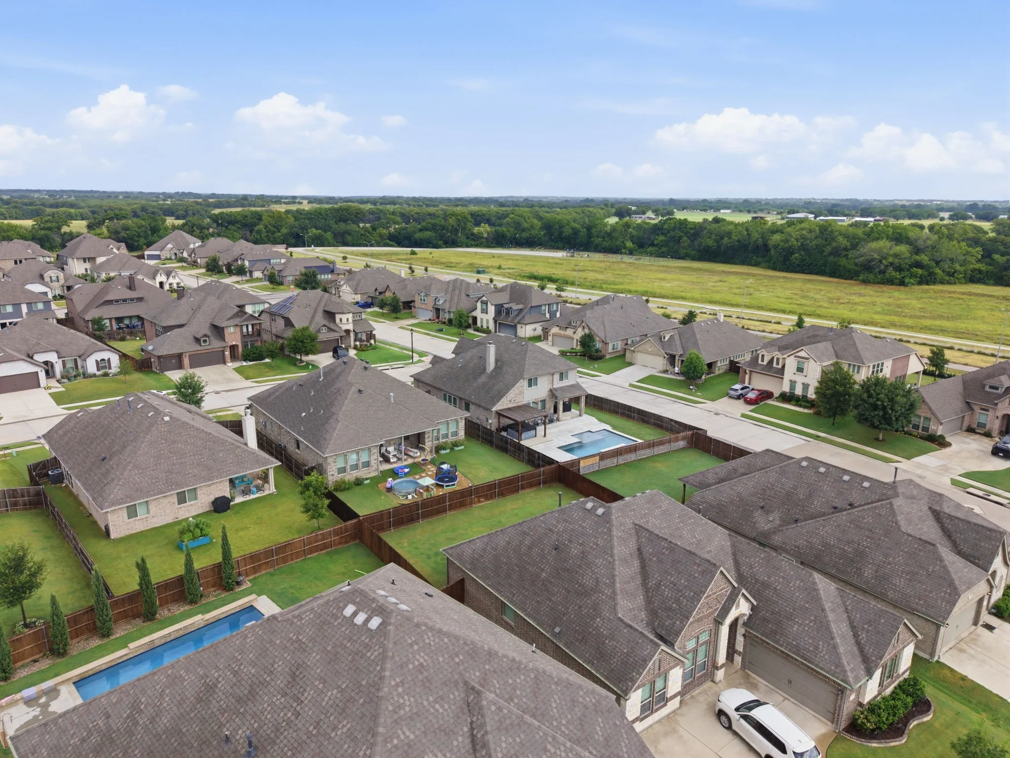 Residential neighborhood with diverse architectural styles, featuring private pools and expansive green spaces
