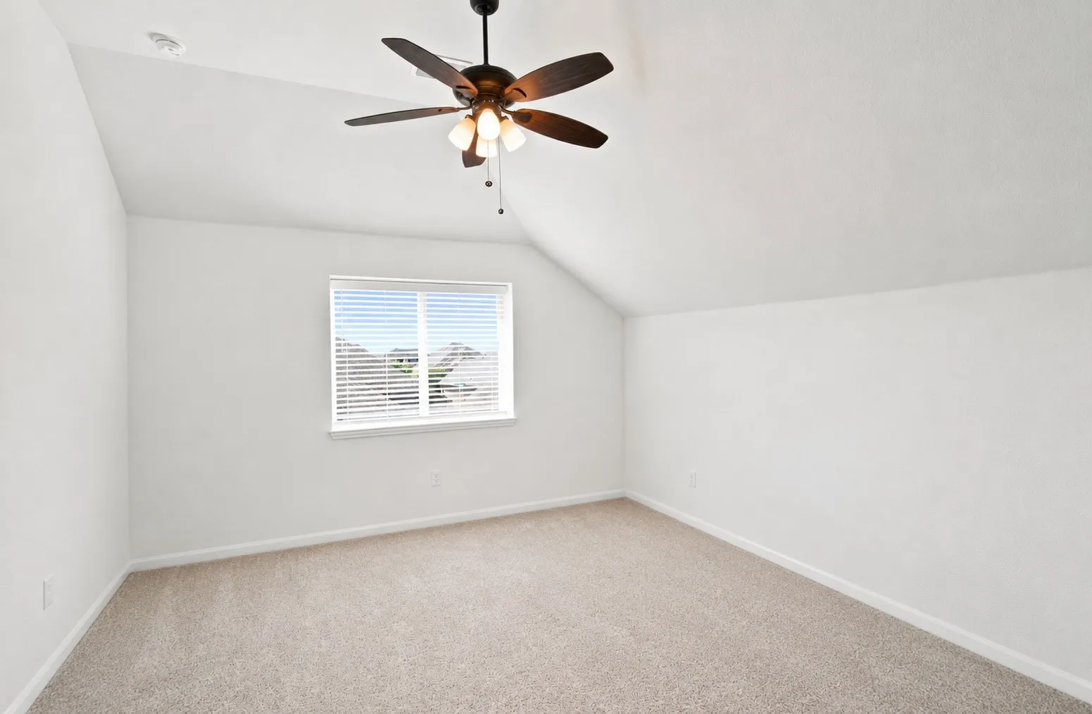 Vaulted ceiling with a ceiling fan, window with blinds, and neutral carpeting