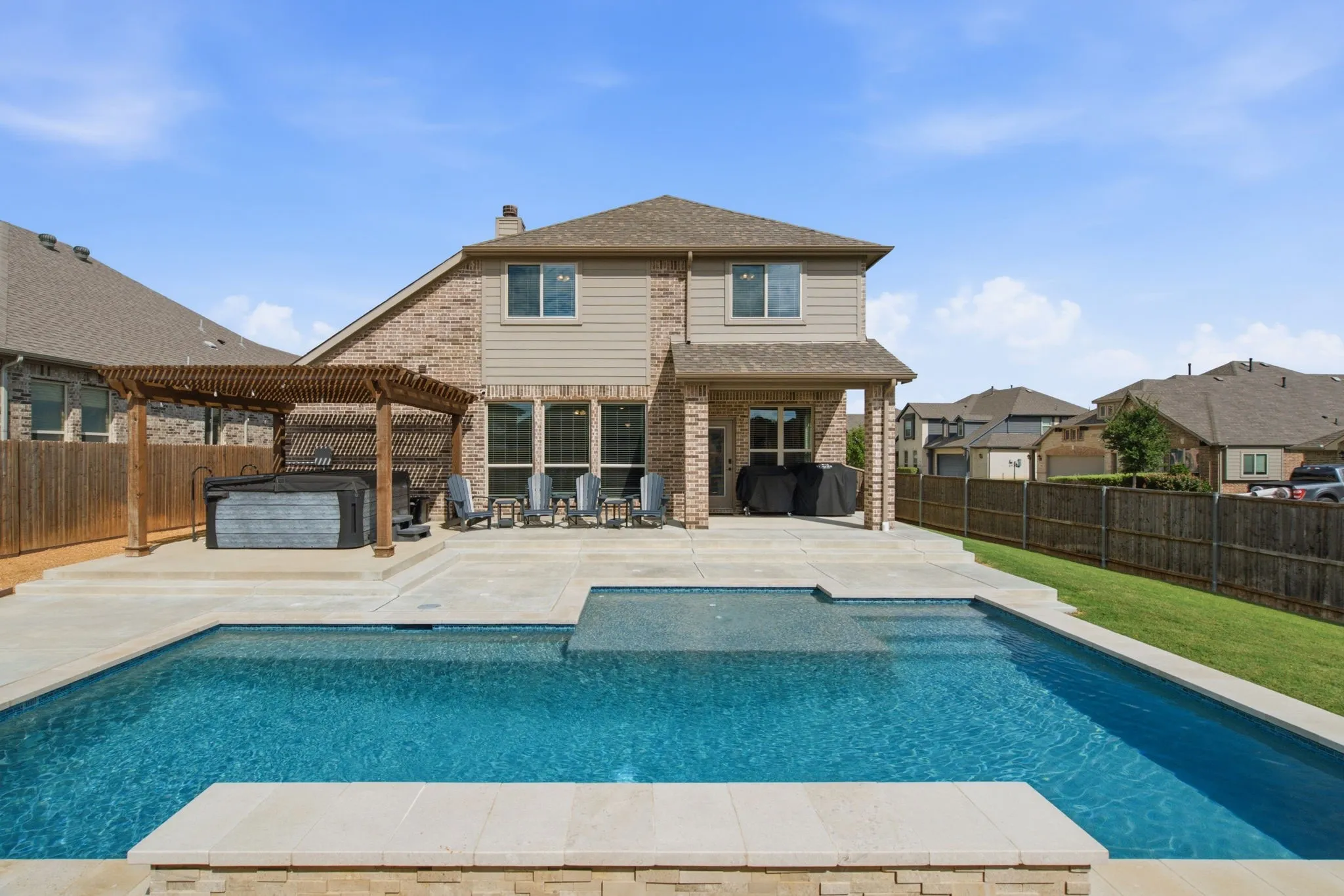 Private backyard featuring an in-ground pool, freestanding spa, and pergola
