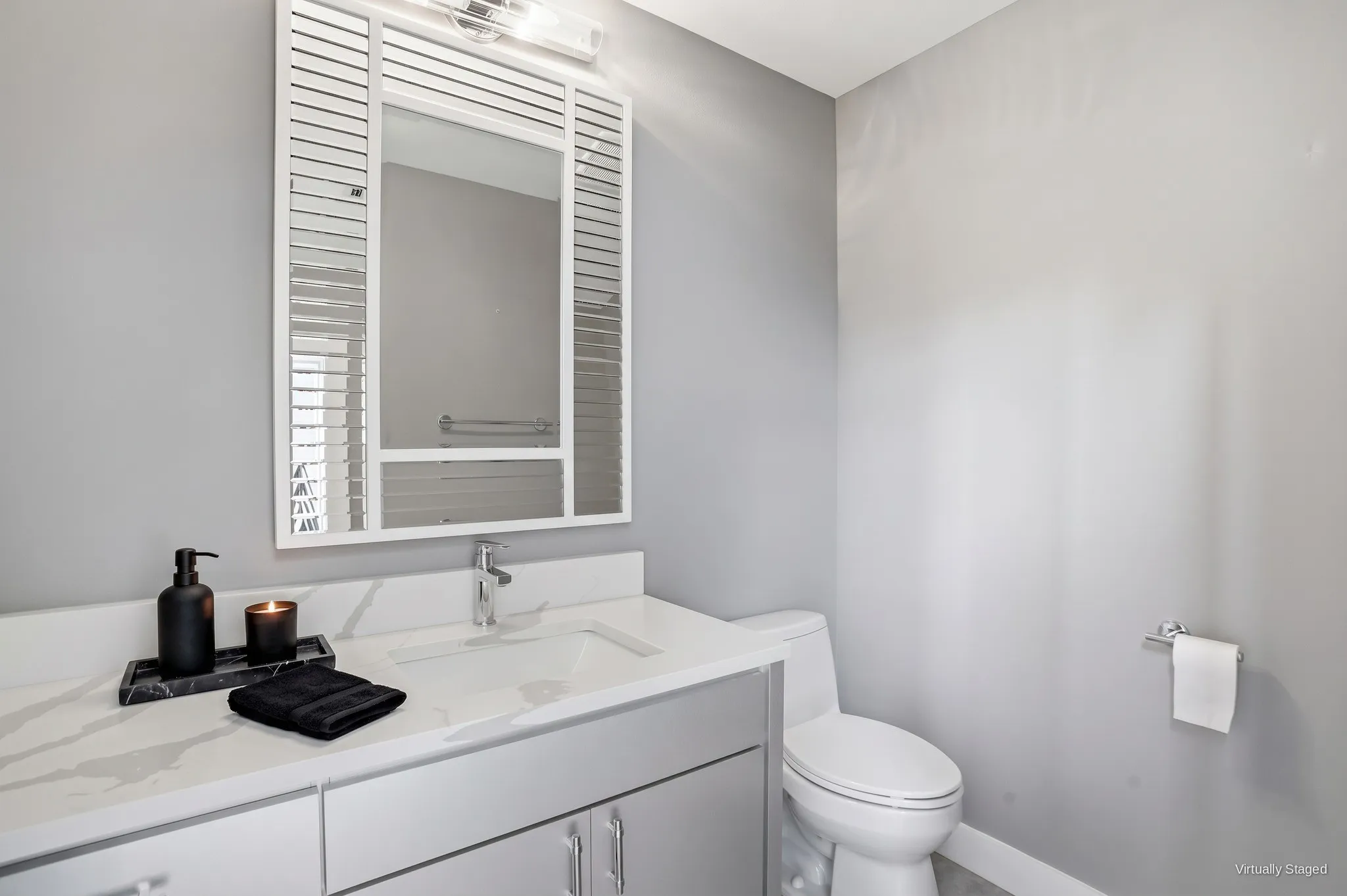 Powder room with a marble-look vanity top and modern fixtures. Virtually staged.