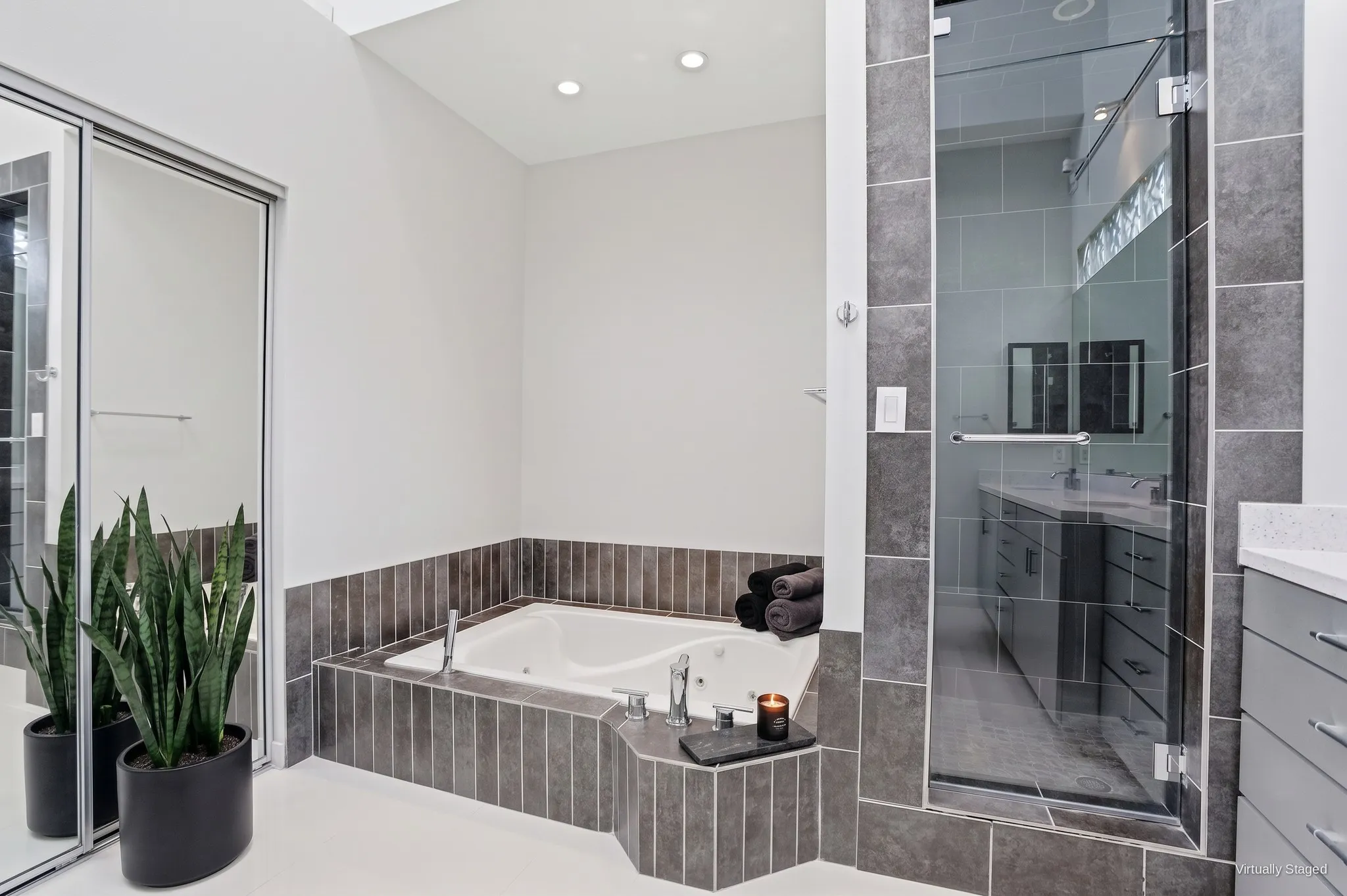 Jetted garden tub and separate glass-enclosed walk-in shower in the primary bath. Virtually staged.