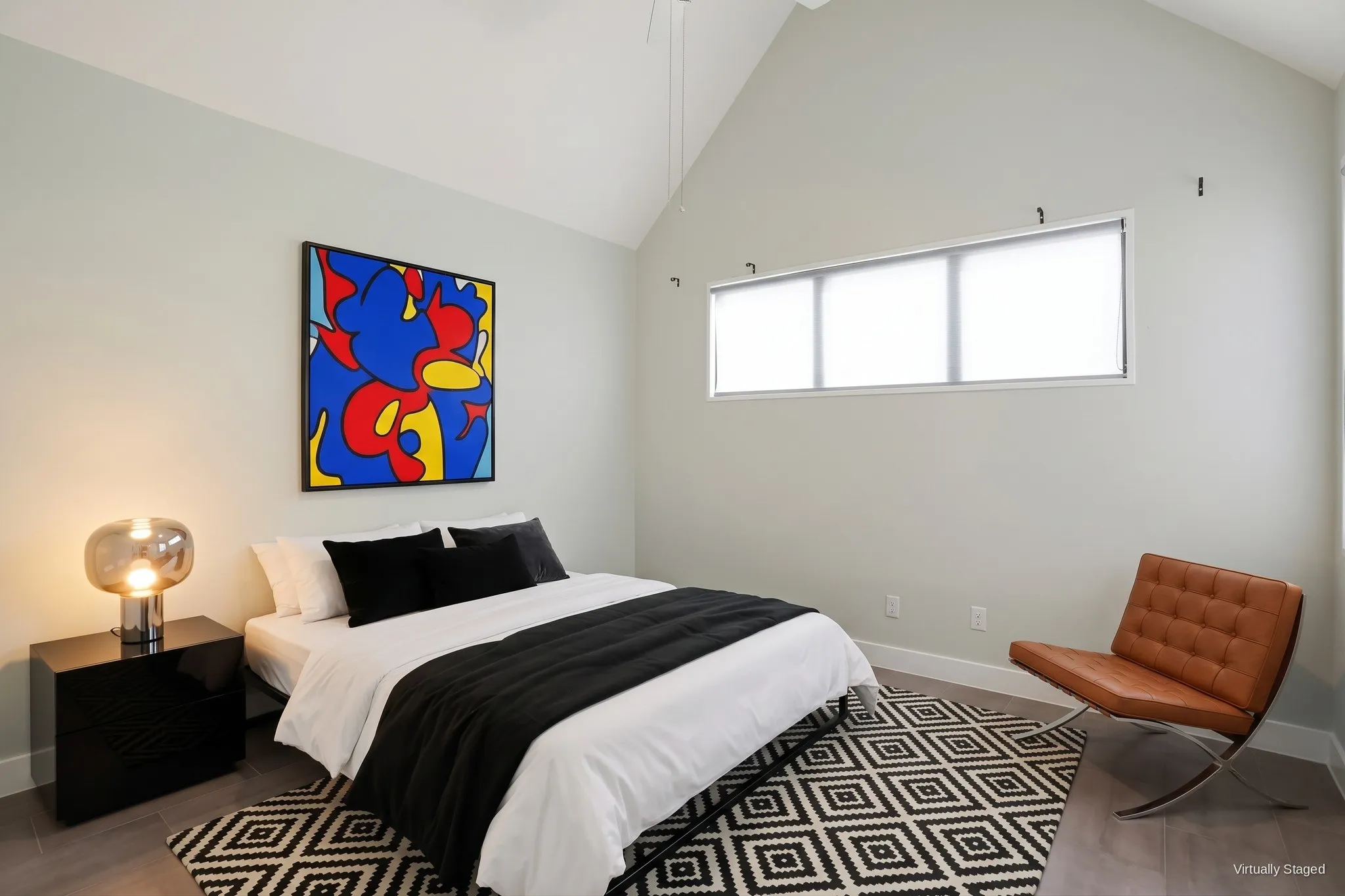 Upstairs bedroom with vaulted ceiling and a clerestory window for privacy and natural light. Virtually staged.