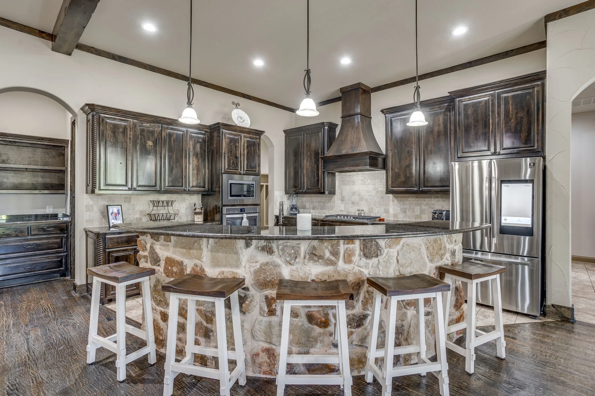 The kitchen includes granite counters, custom cabinetry, stainless steal appliances, gas stove top, walk-in pantry, butler's panty and small wine room.