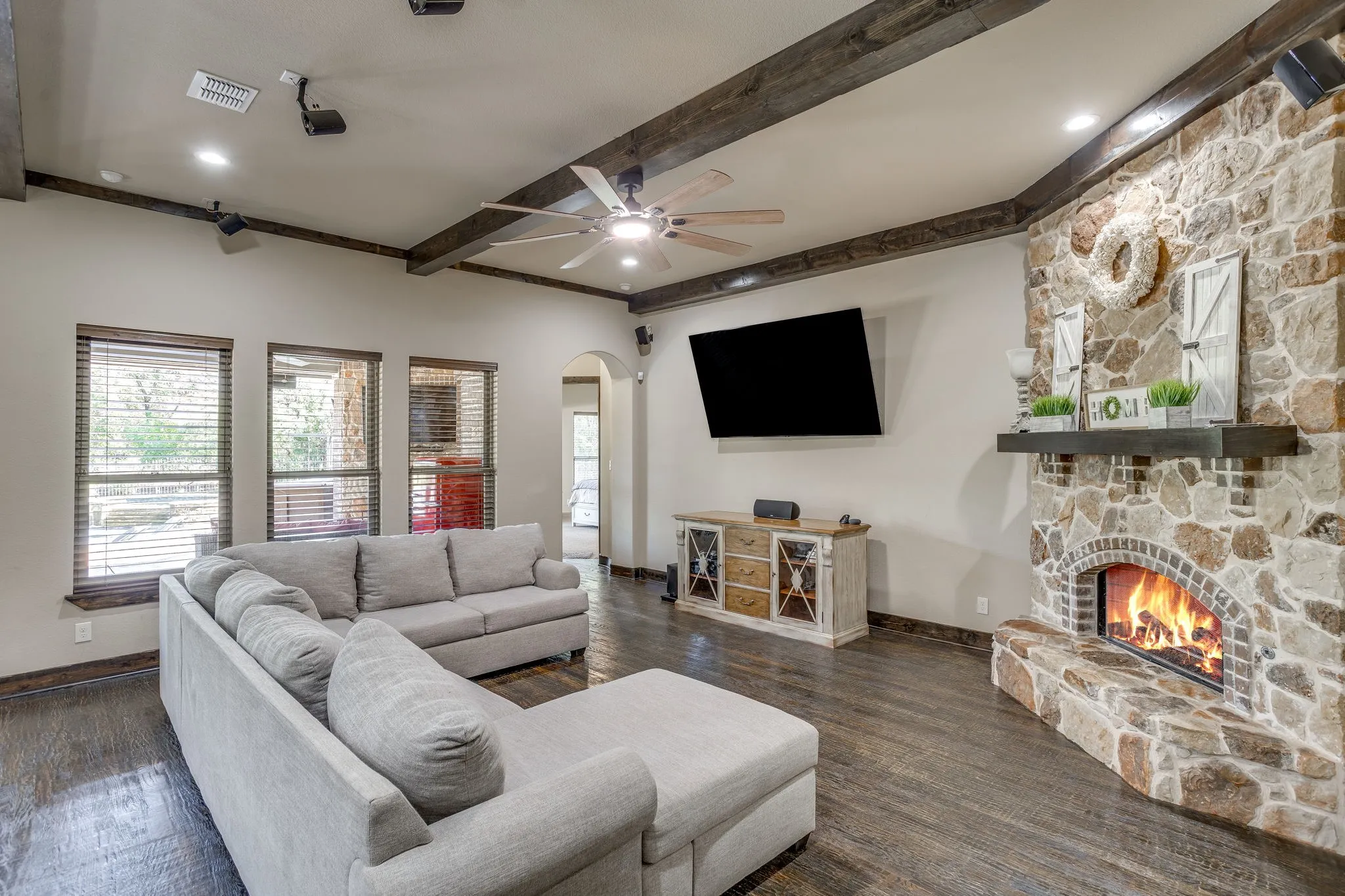 The spacious living area features hand scraped wood floors, stone fireplace and beamed ceilings.