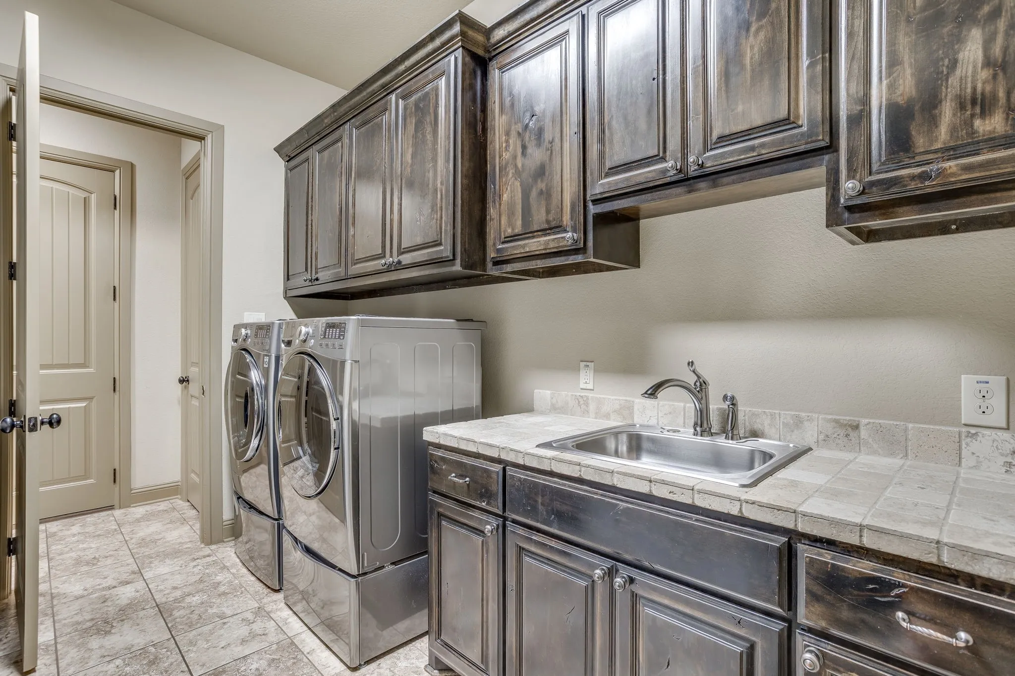 The spacious utility room has plenty of storage, a sink, drip dry area and room for a freezer.