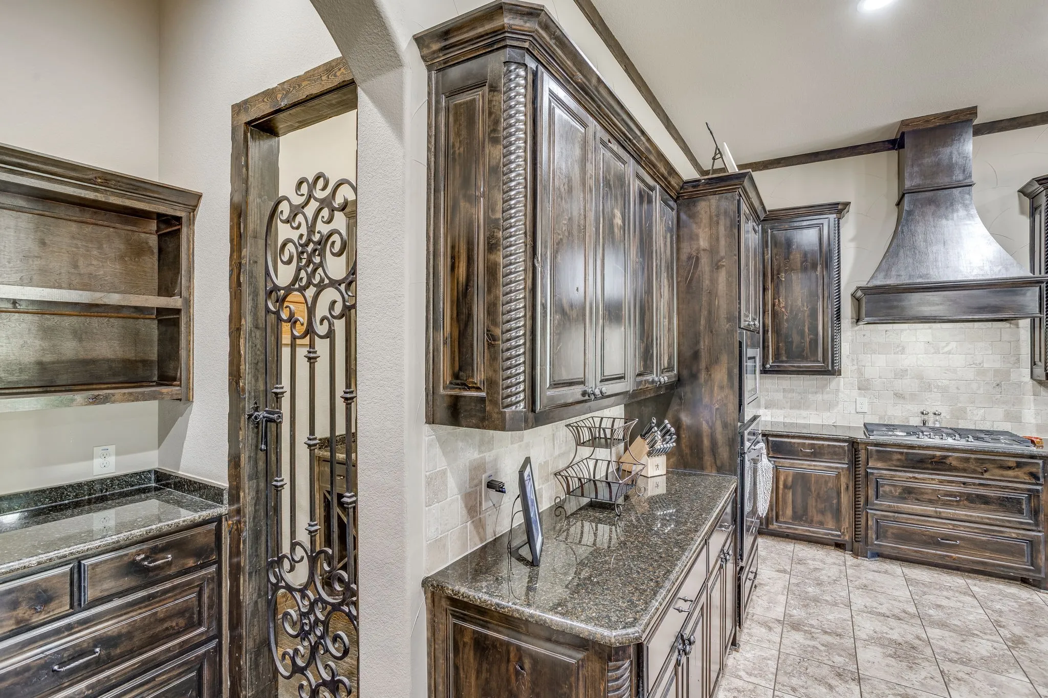 The kitchen includes granite counters, custom cabinetry, stainless steal appliances, gas stove top, walk-in pantry, butler's panty and small wine room.