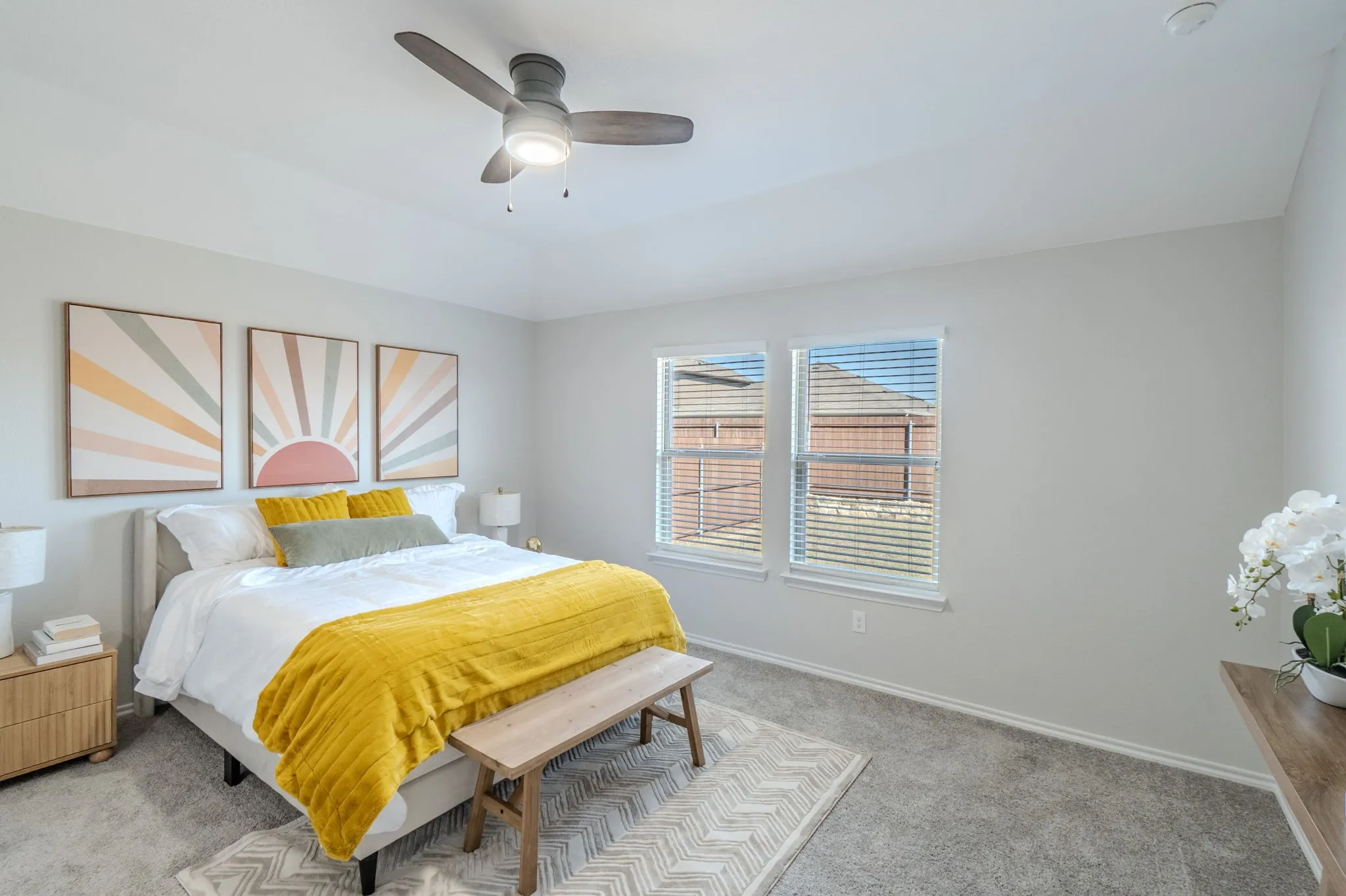 Tray ceiling with a ceiling fan, two windows with blinds, and light-toned wall-to-wall carpeting
