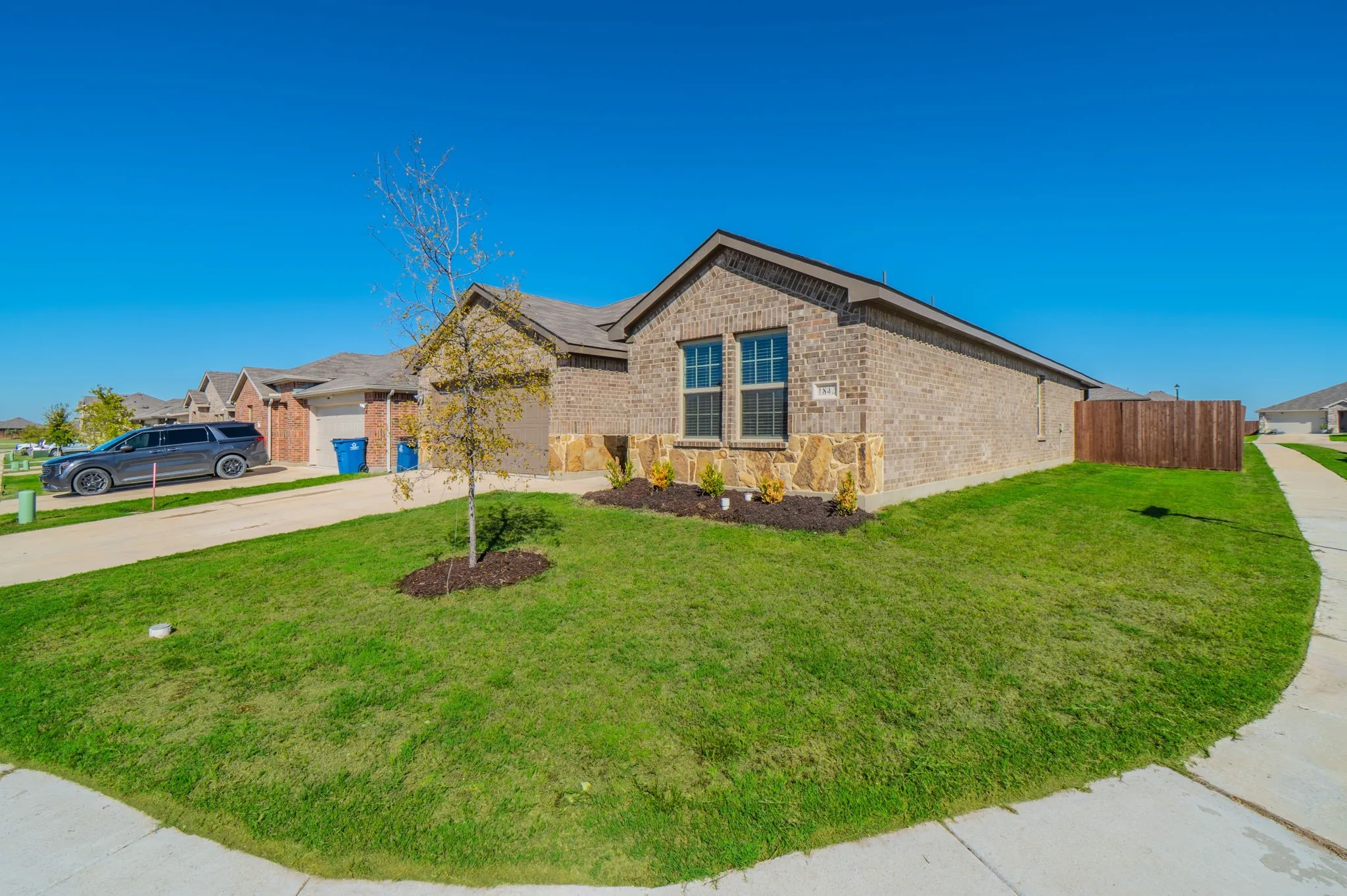 Brick and stone exterior with architectural detail, complemented by manicured landscaping and mature plantings