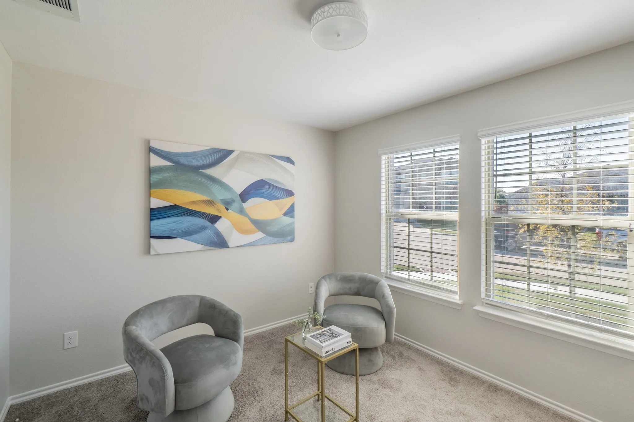 Recessed ceiling lighting, two windows with blinds, and light gray wall paint