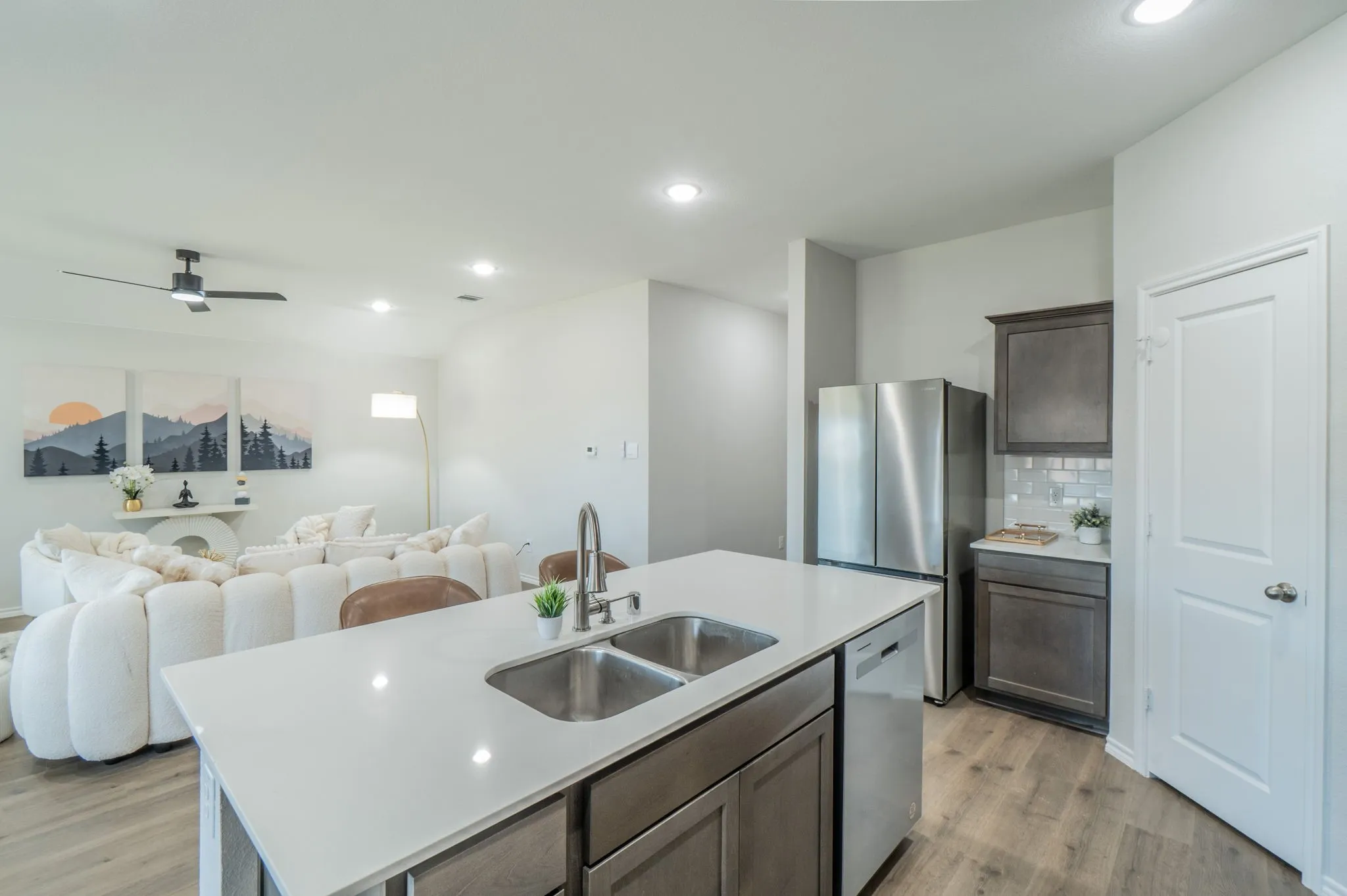 Open-concept living area with wood-finish flooring, recessed lighting, and a contemporary ceiling fan