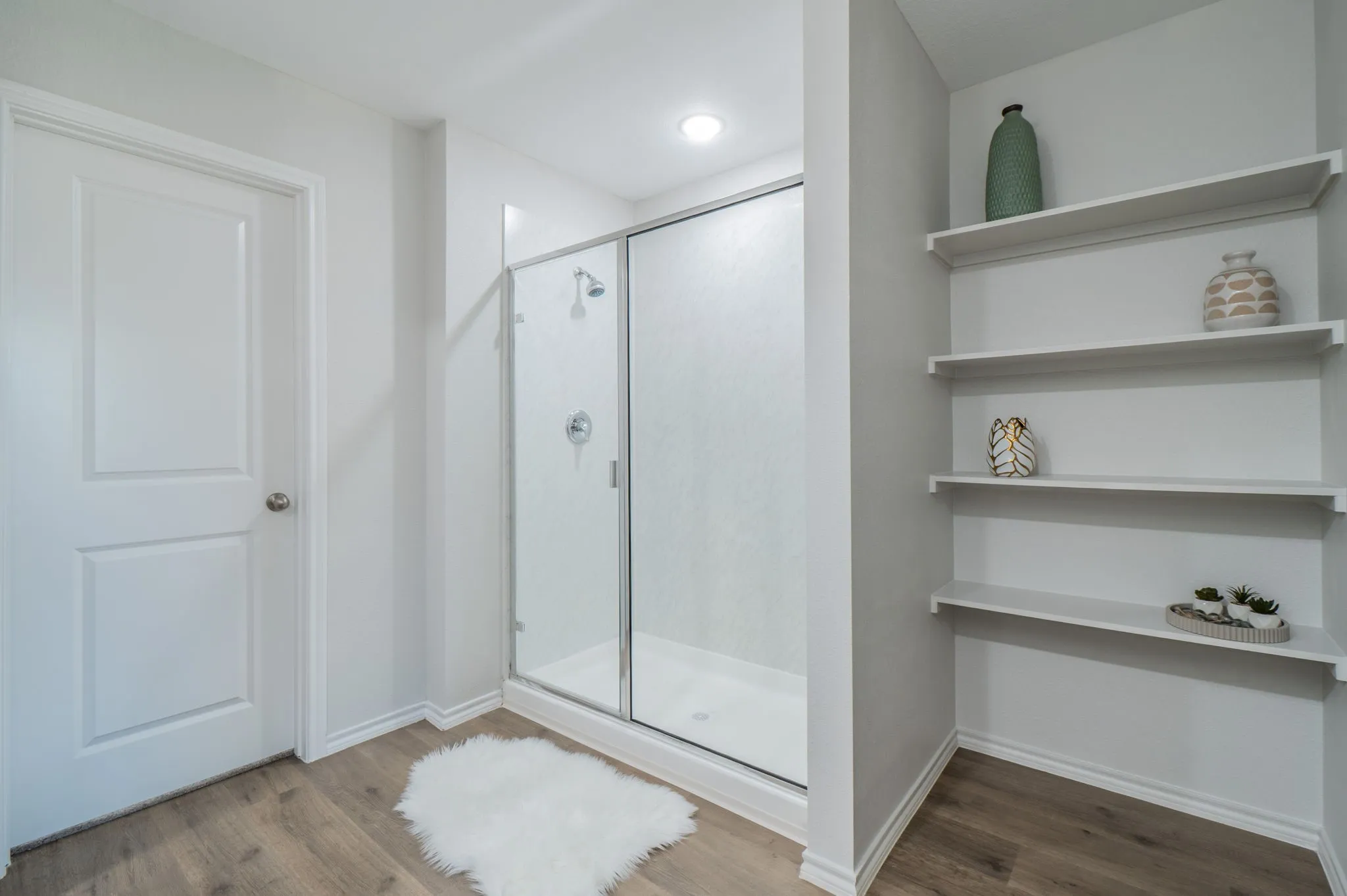 Walk-in shower with clear glass enclosure and chrome fixtures