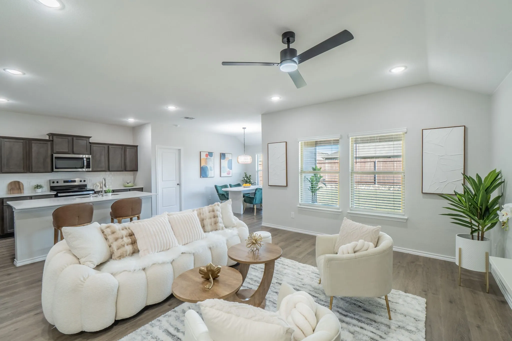 Open-concept living area featuring wood-finish flooring, recessed lighting, and a modern ceiling fan