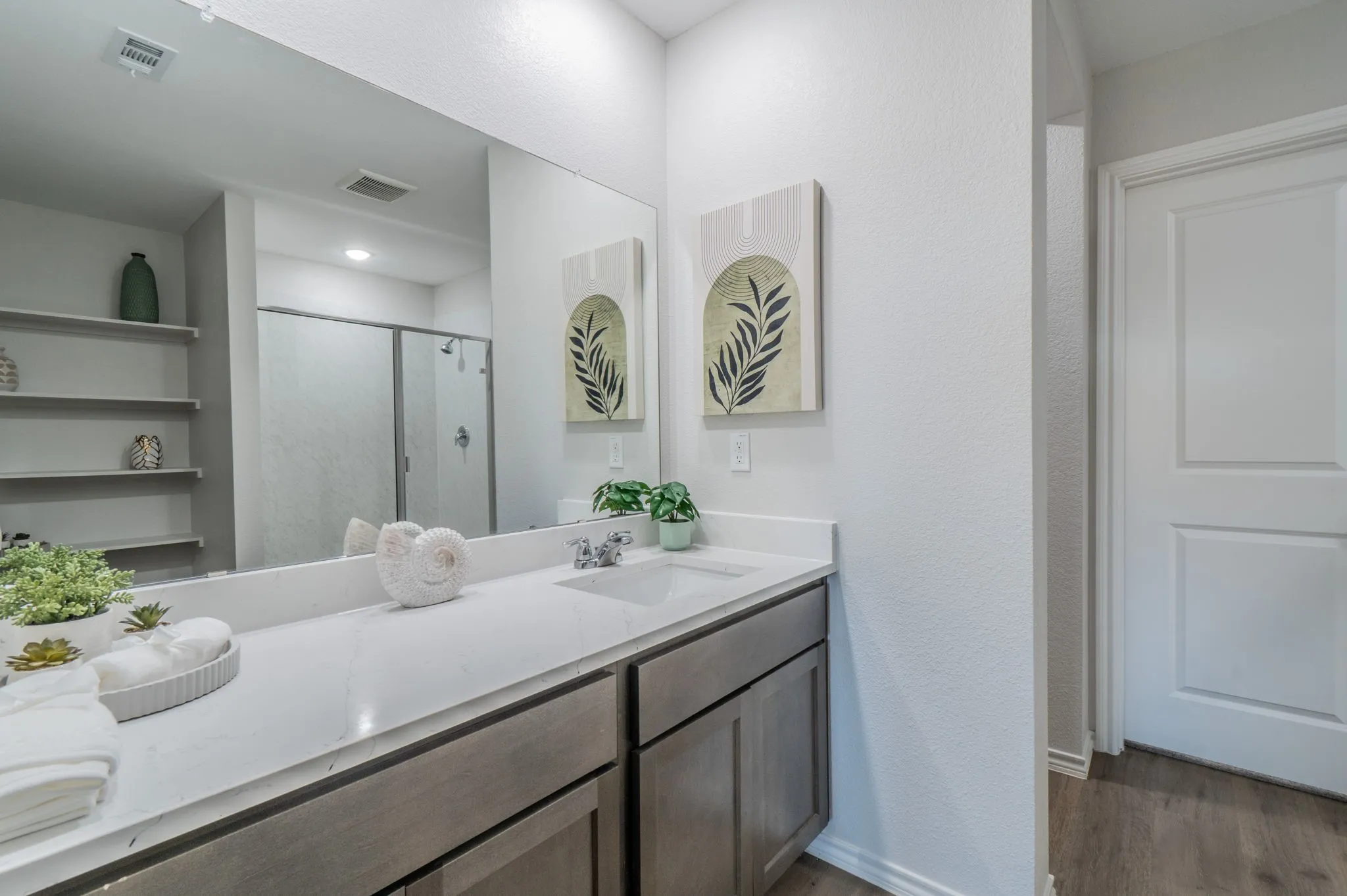 Dual vanity with an integrated sink, polished chrome faucet, and gray wood-finish cabinetry