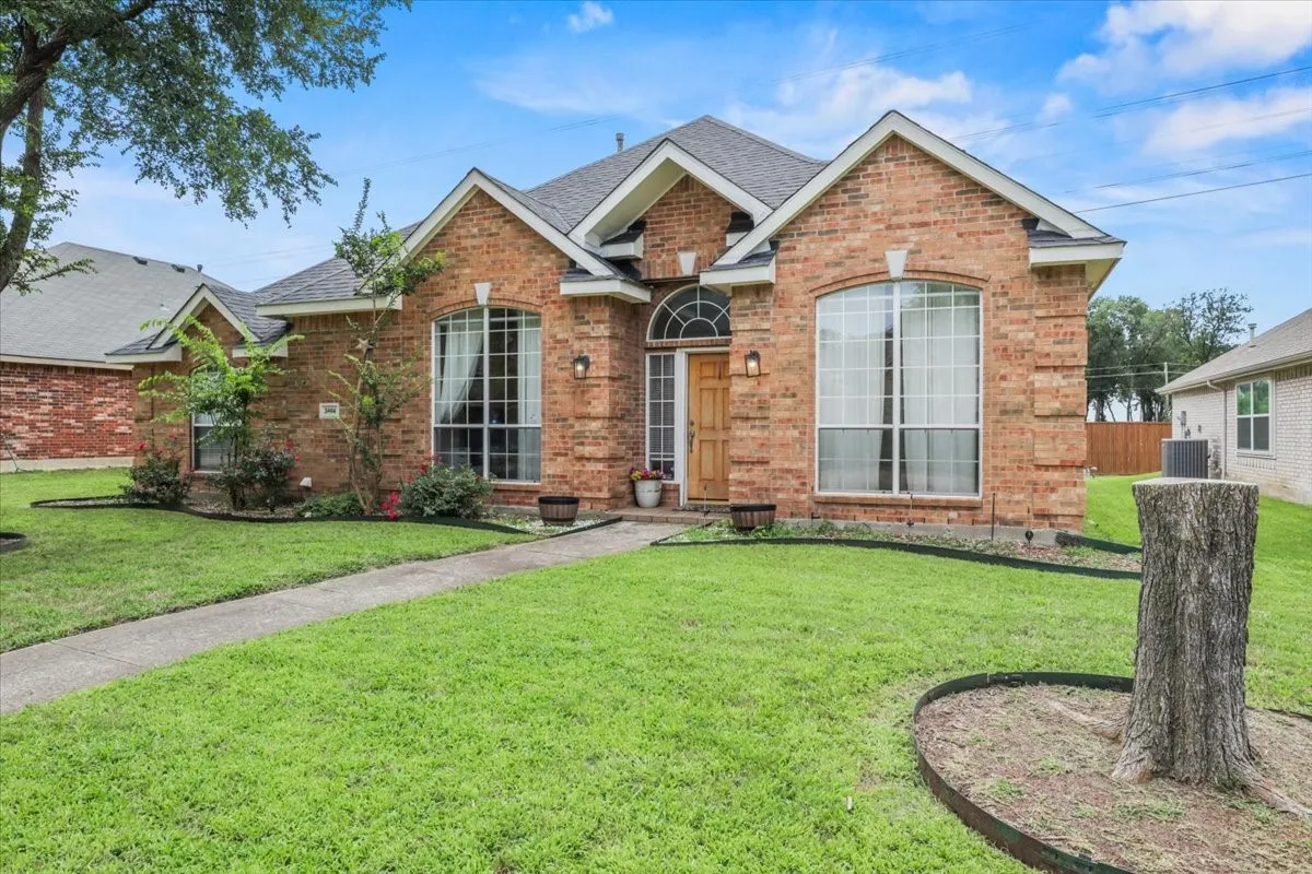 Brick exterior with arched windows, prominent gables, and a wood-finish entry door