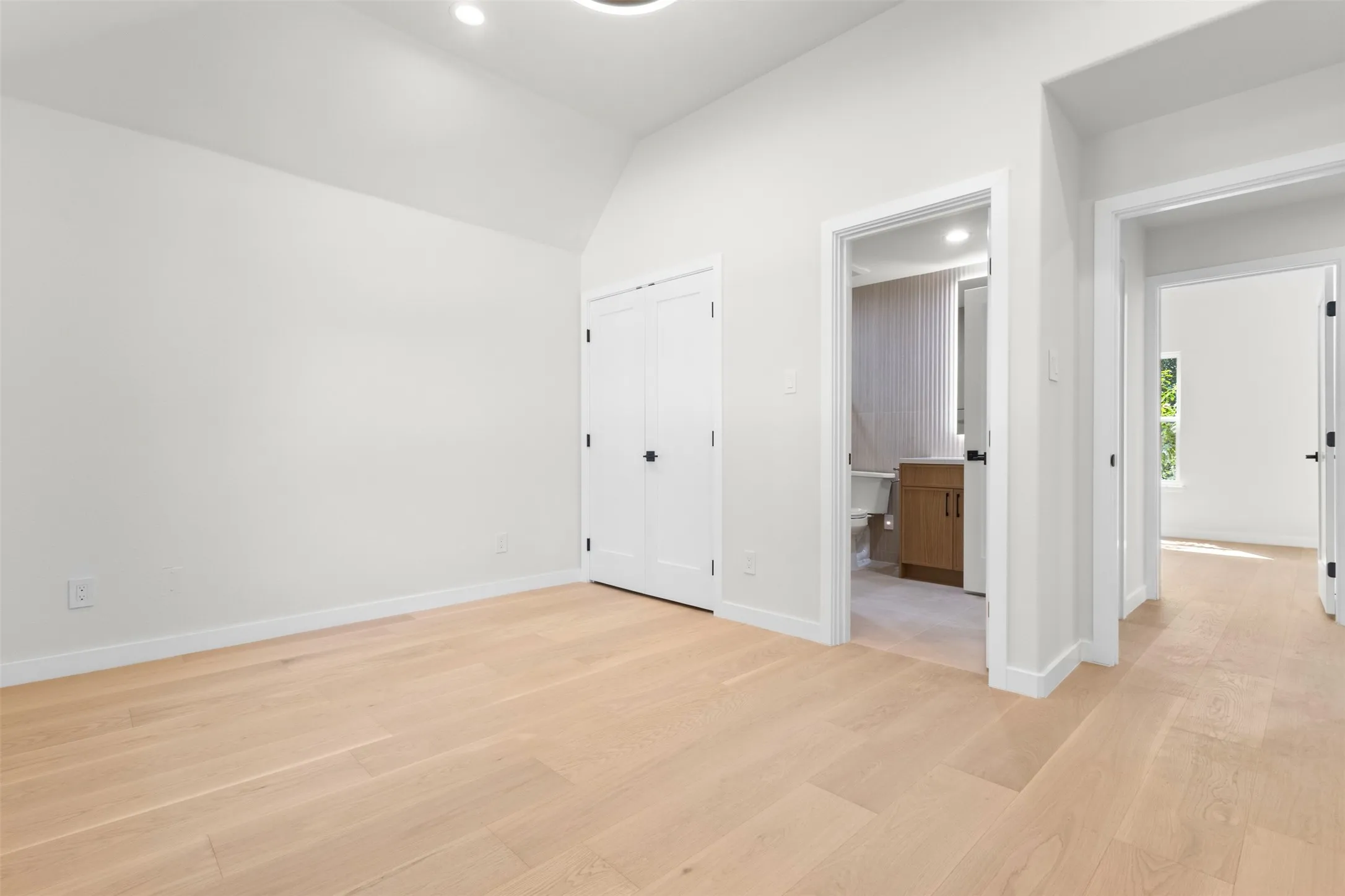 Light wood-finish flooring with white baseboards