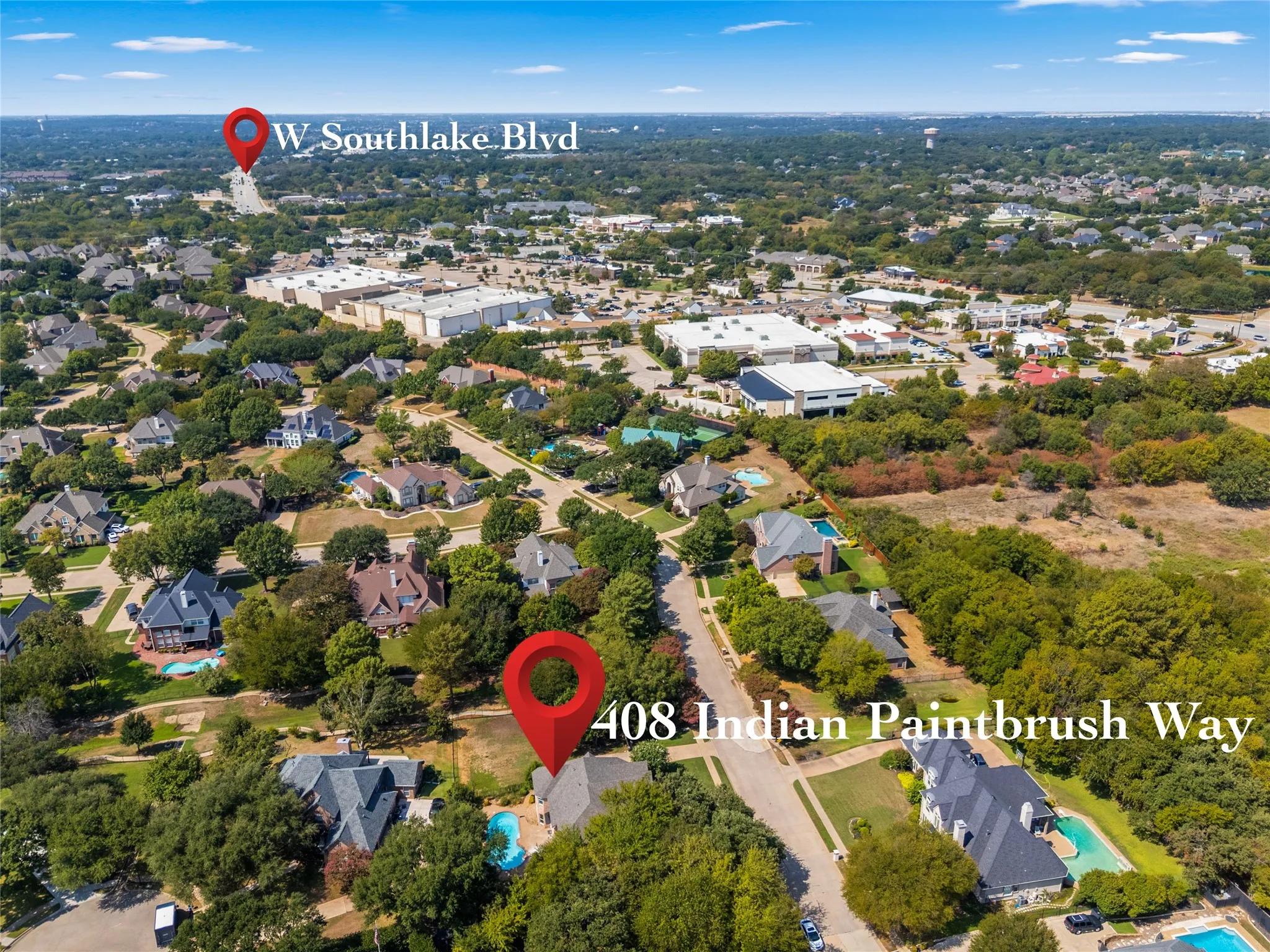 Aerial view of a residential neighborhood with ample green space and mature trees