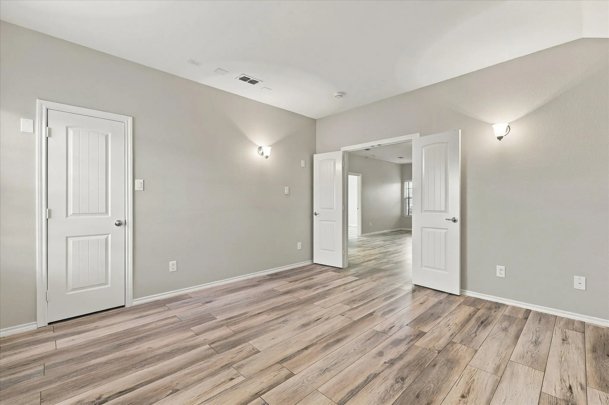 Wood-finish flooring, light gray wall tones, and white trim