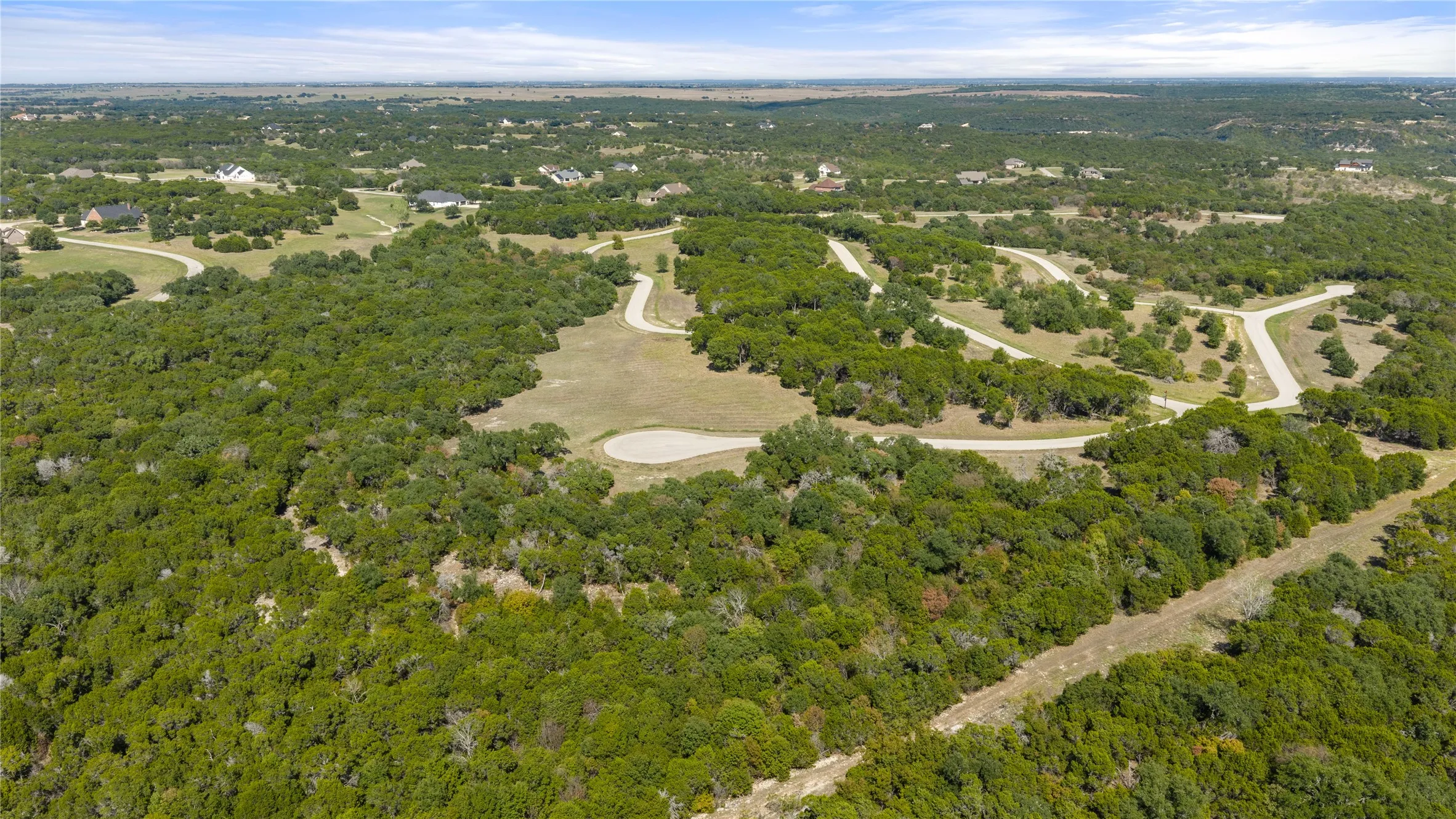 Extensive wooded landscape with established paved roads and scattered residential structures