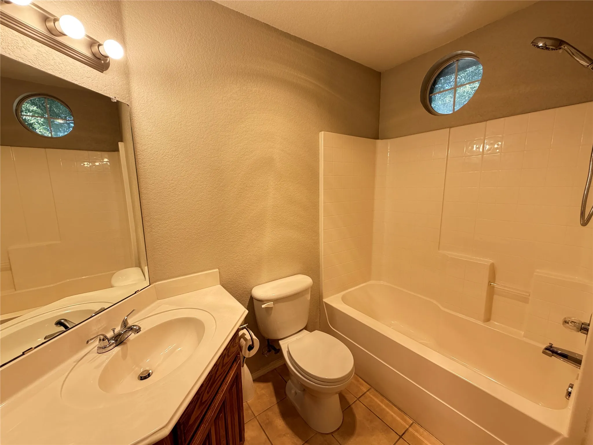 Bathroom with a single vanity, integrated sink, and wood-finish cabinetry
