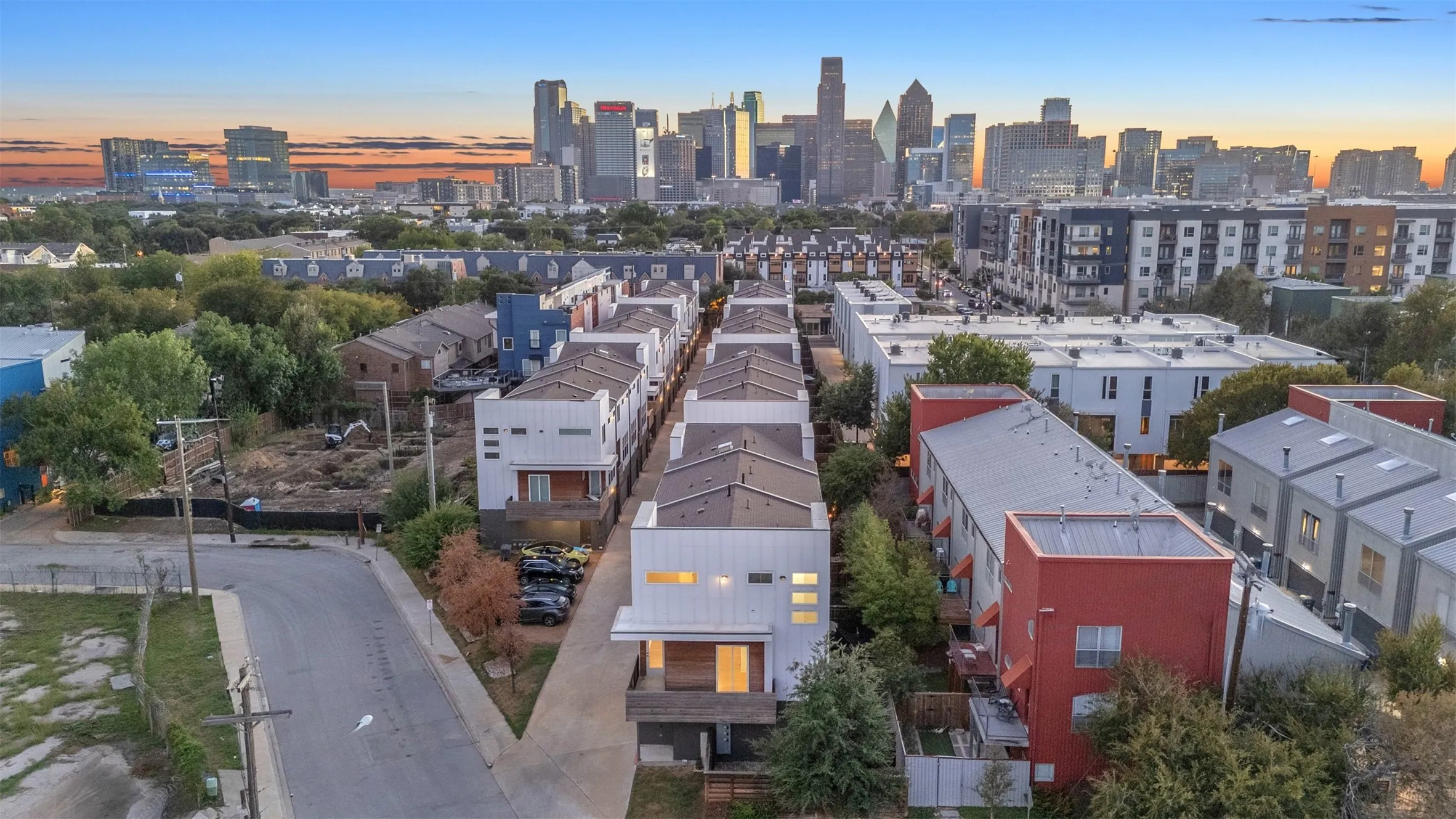 Elevated view of the 1510 N Washington community and shared drive with the Downtown Dallas skyline at sunset
