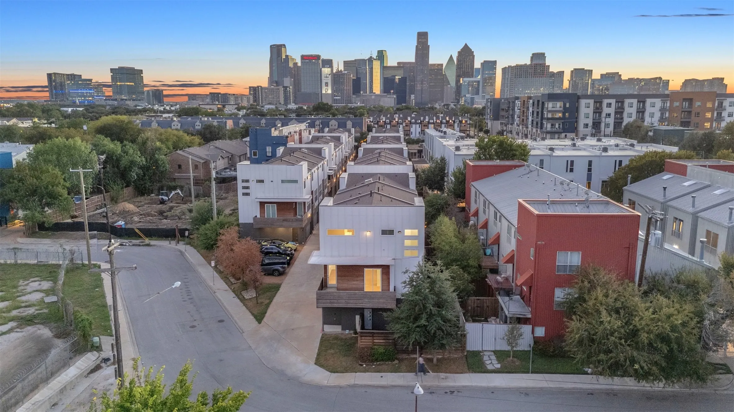 Drone view down the side street toward the Downtown Dallas skyline, with this corner unit in the foreground