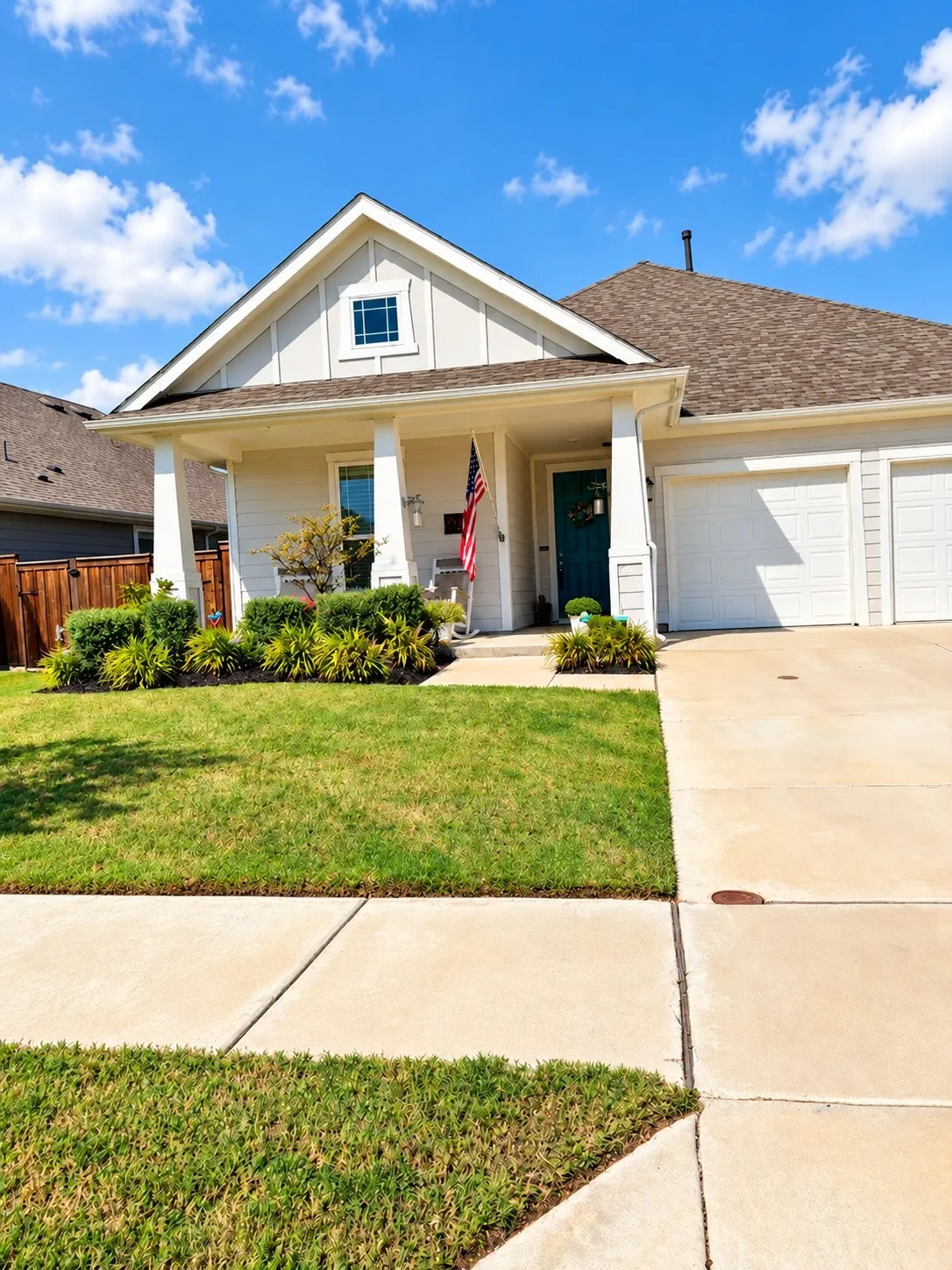Gable roofline with a decorative window, covered front porch, vibrant blue entry door, two-car garage, and a concrete driveway