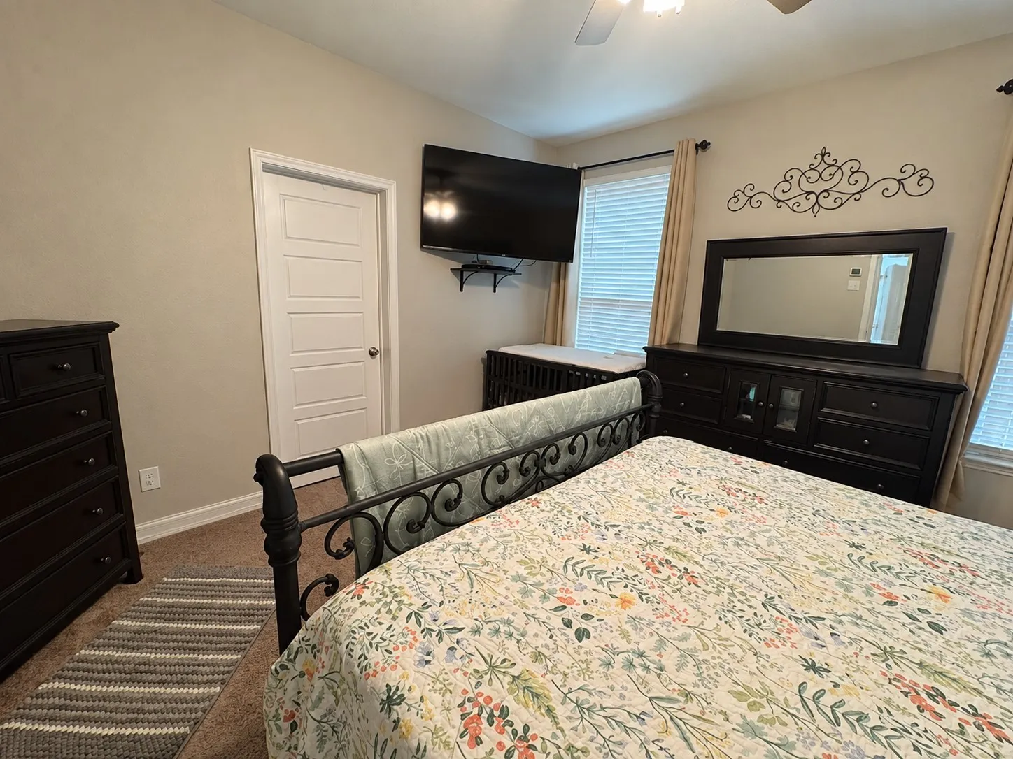 Carpeted flooring, paneled interior door, and window with blinds