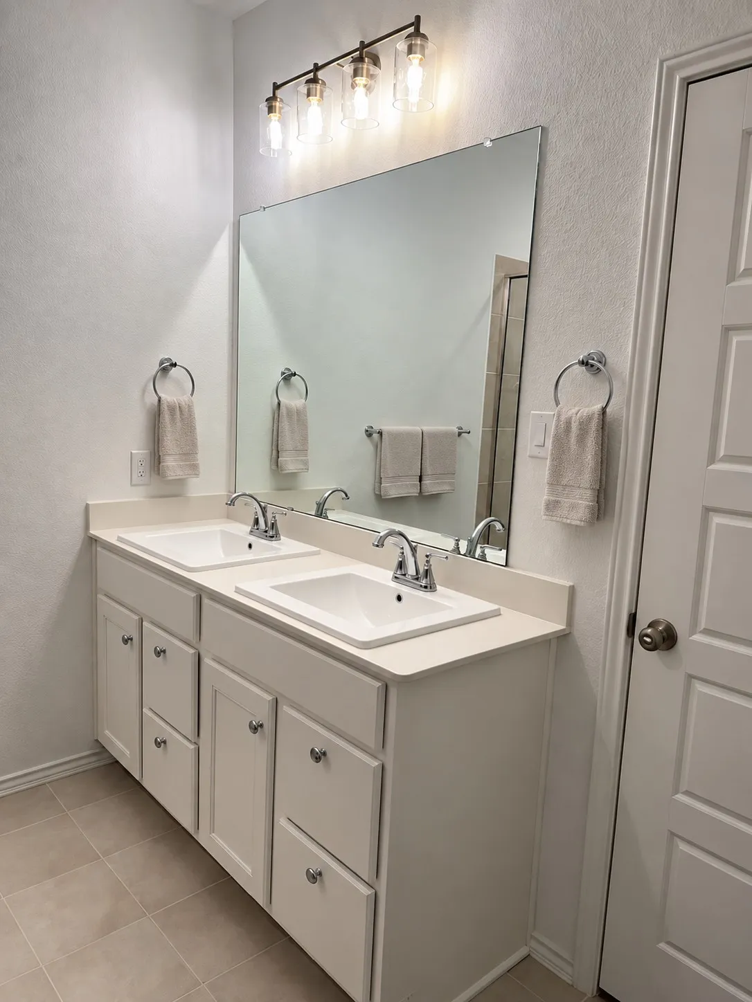 Dual vanity with undermount sinks, chrome faucets, and a full-width mirror
