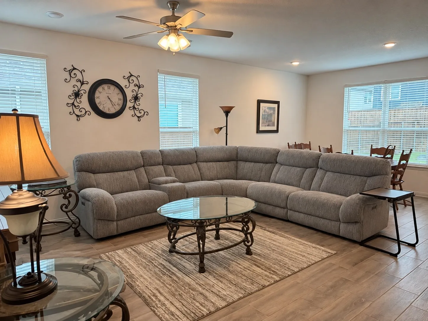 Recessed lighting, ceiling fan, wood-finish flooring, multiple windows with blinds, and an open-concept layout