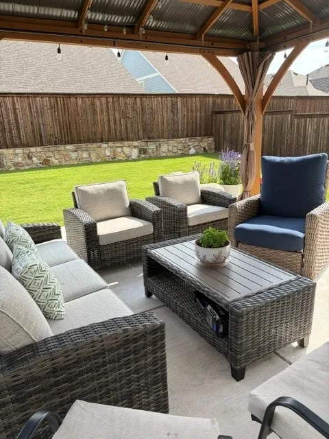 Covered patio featuring a corrugated metal roof, string lighting, and wood posts
