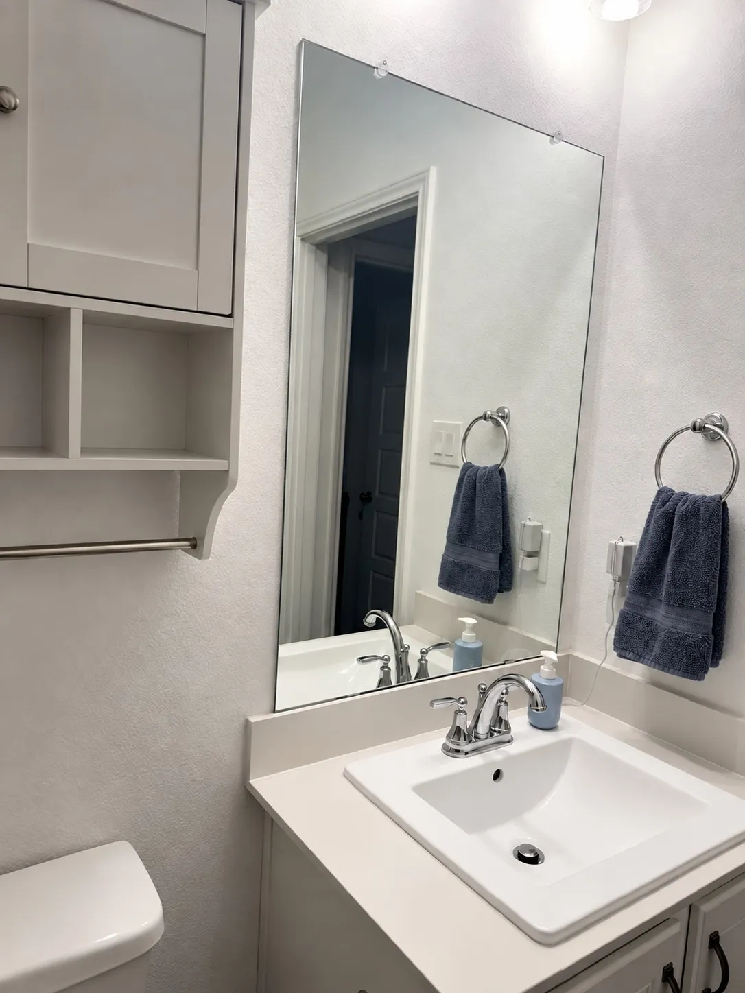 Vanity with an integrated rectangular sink, chrome-finish faucet, and light-toned countertop